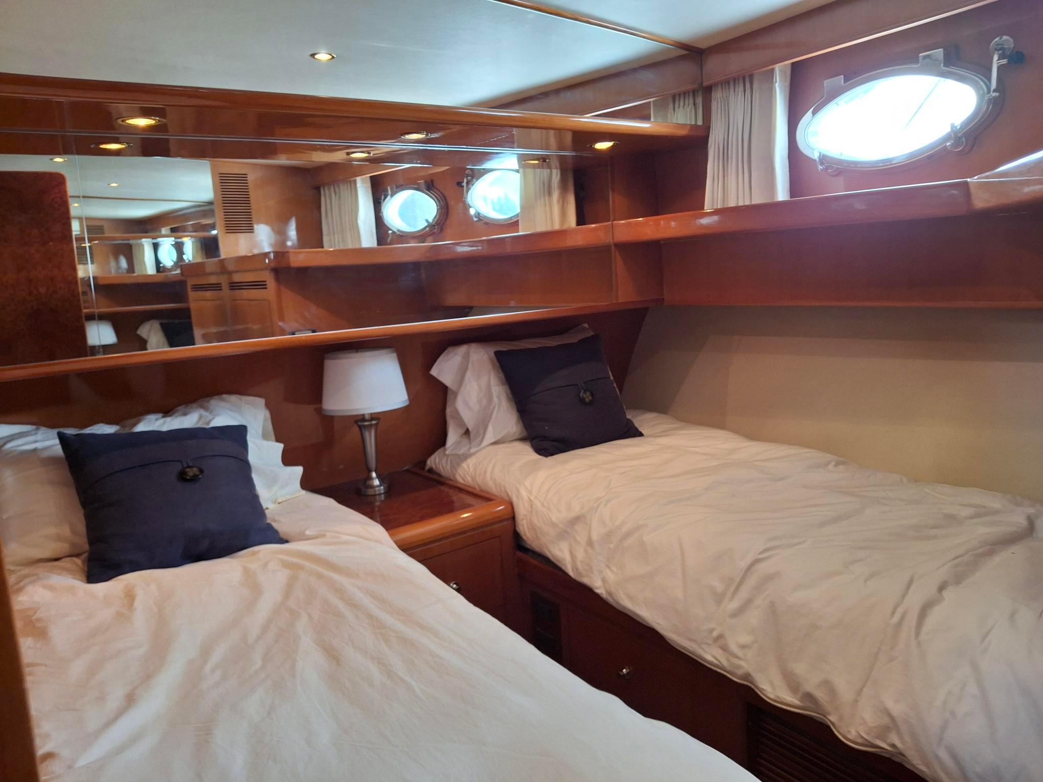 Luxurious twin cabin in 2004 Ocean Alexander 64 Pilothouse yacht with elegant wood finish.
