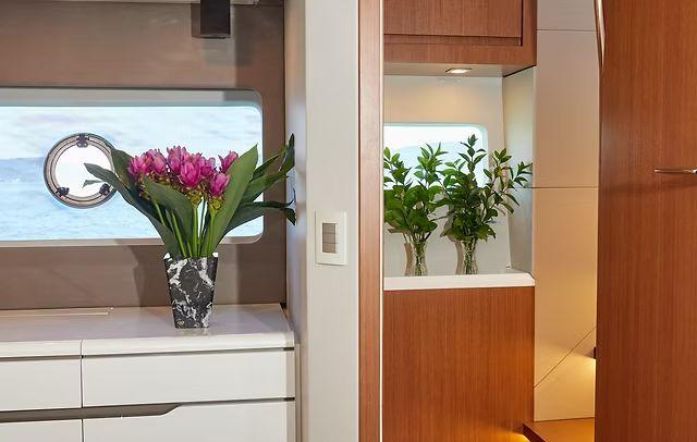 Luxurious Schaefer 660 yacht interior with elegant floral decor, modern cabinetry, and ocean view.