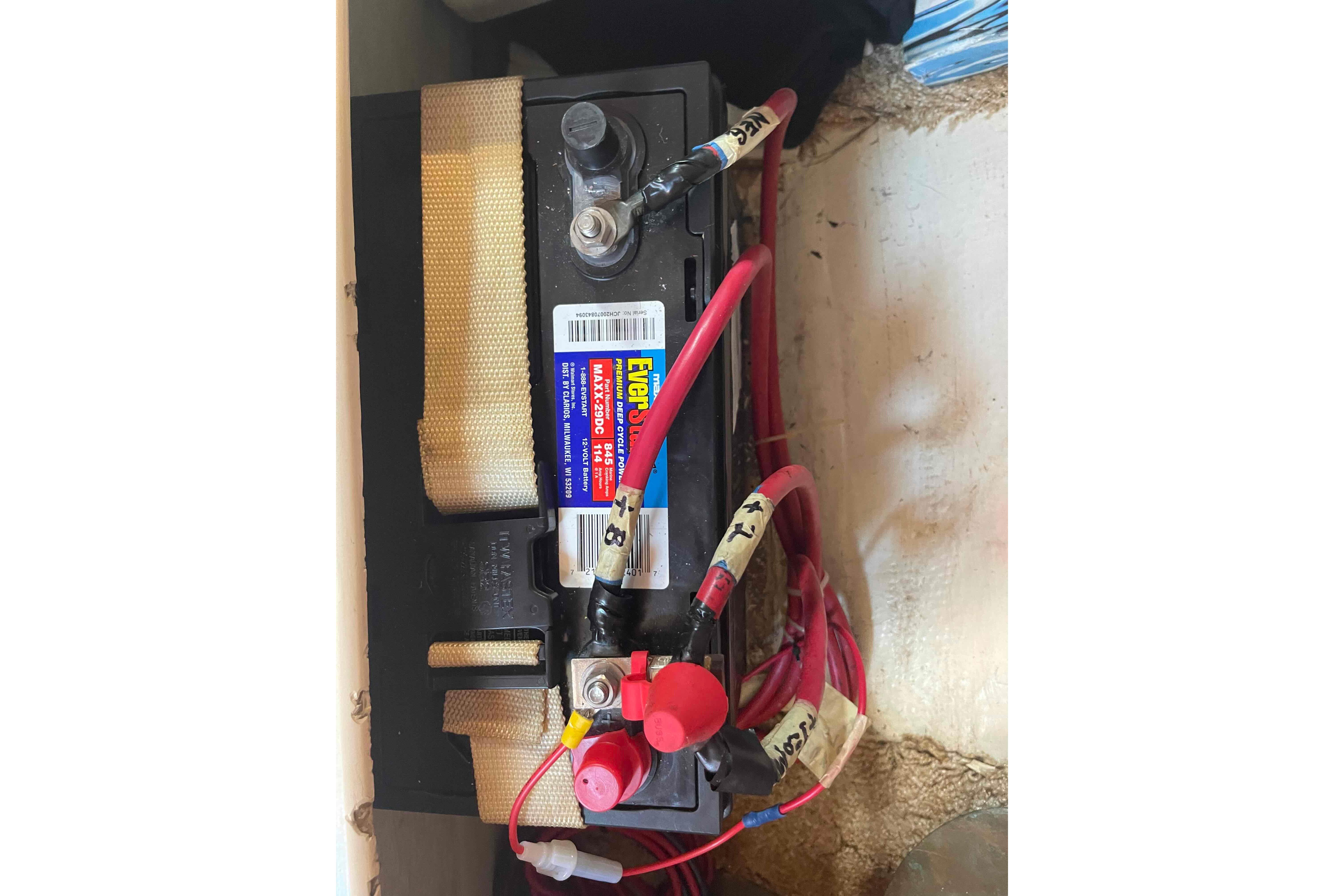 Battery setup in a 1987 Pacific Seacraft 34 sailboat with labeled red cables.
