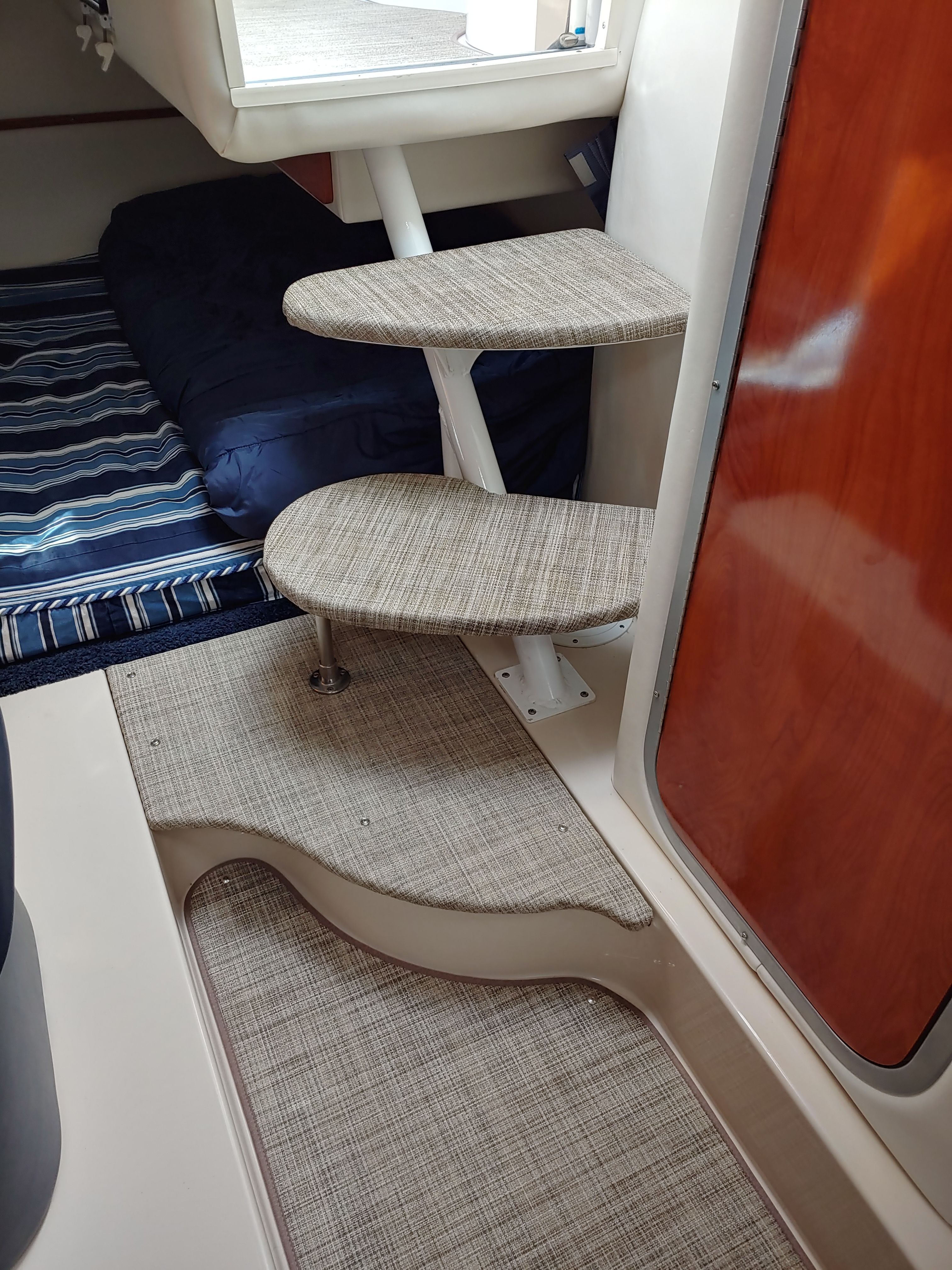 Interior of a boat with stairs and sleeping area.