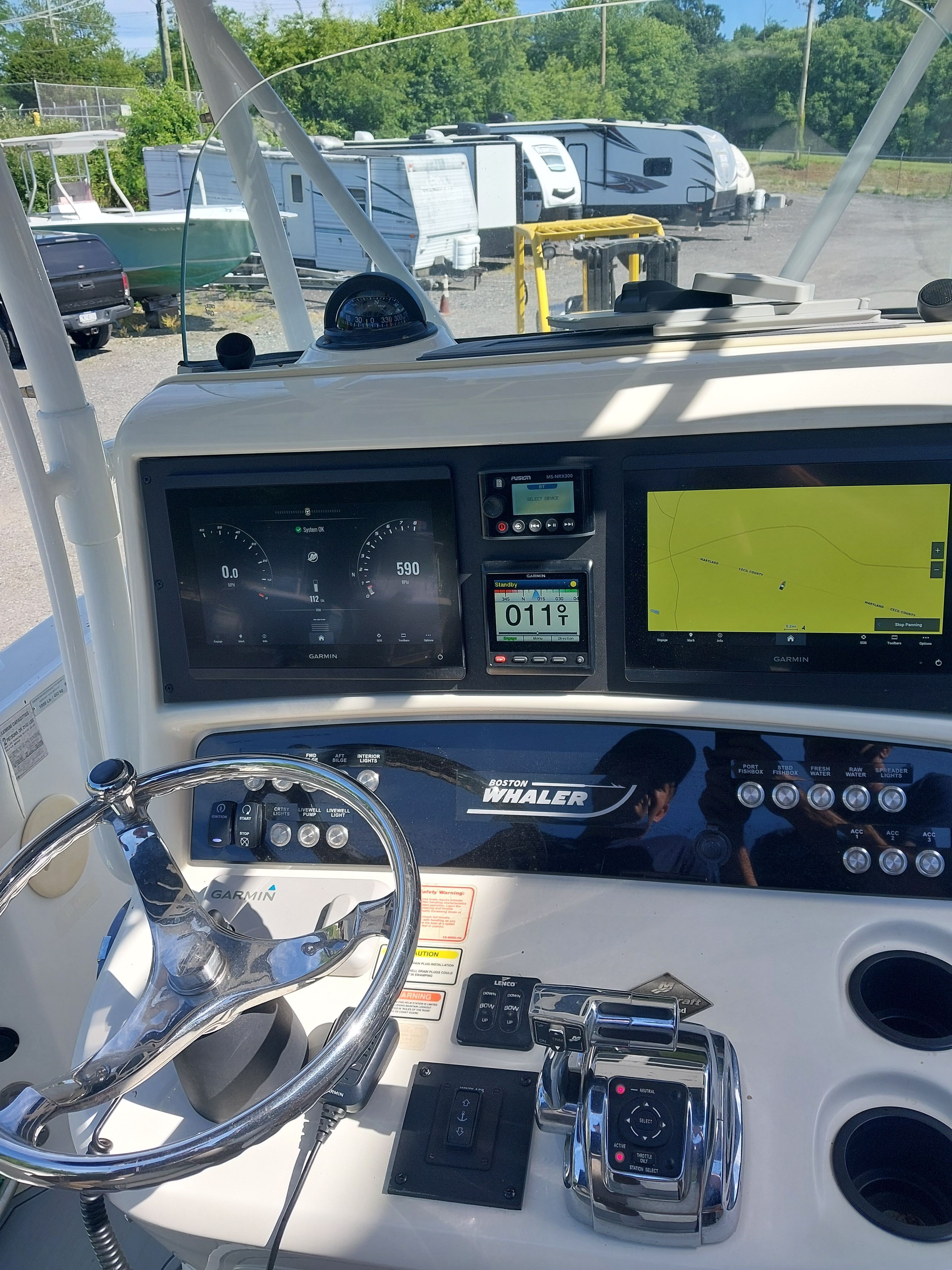 The image shows the cockpit of a 2005 Boston Whaler 240 Outrage with modern instruments.