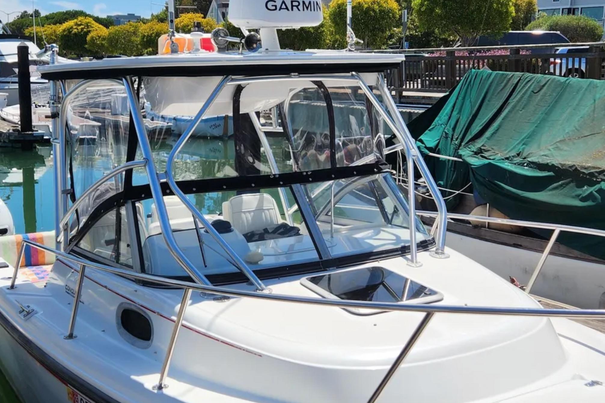2000 Boston Whaler 21 Conquest boat docked, featuring a sleek design and Garmin equipment.