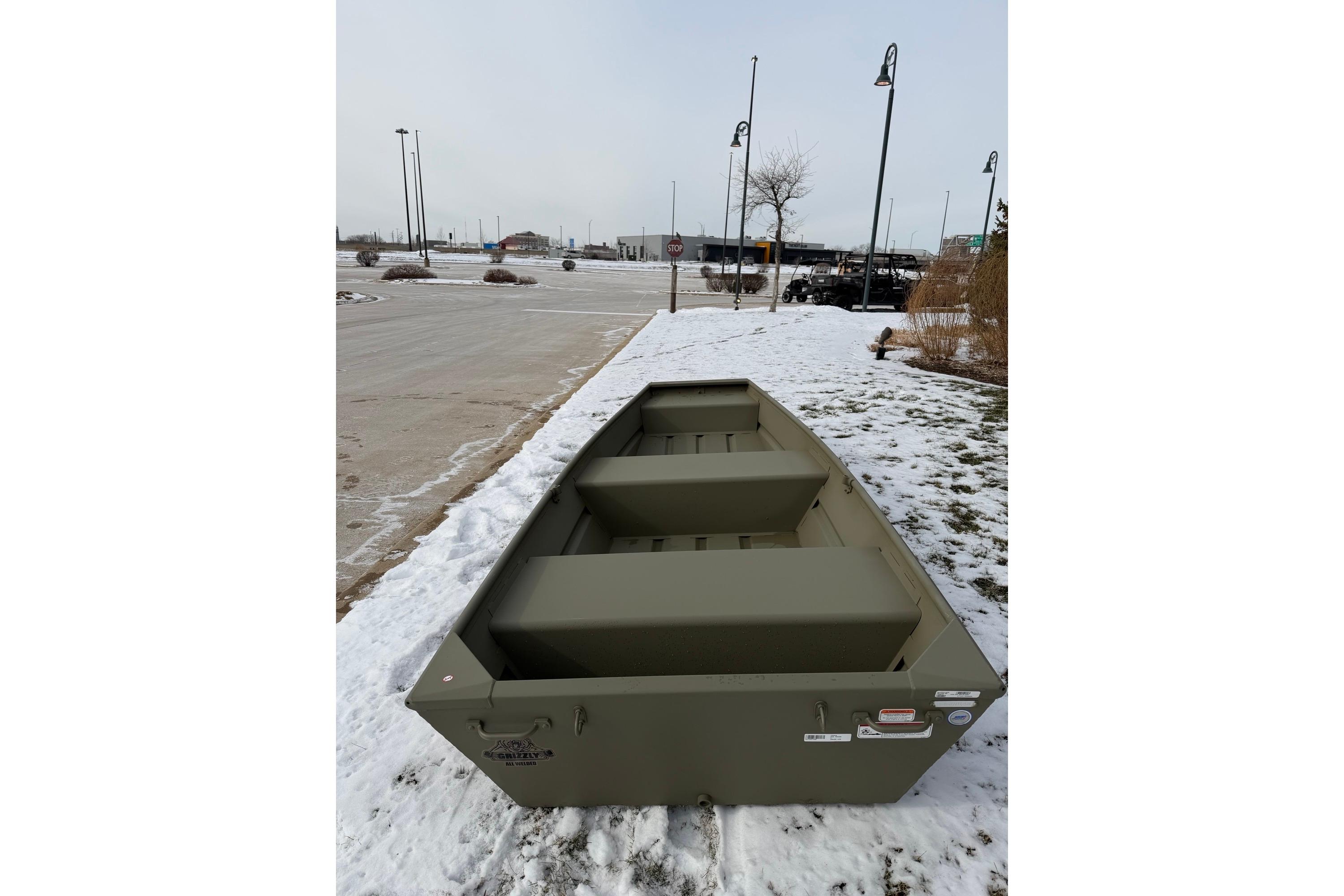 2026 Tracker Grizzly 12 Jon boat on snowy ground, showcasing its sturdy design.