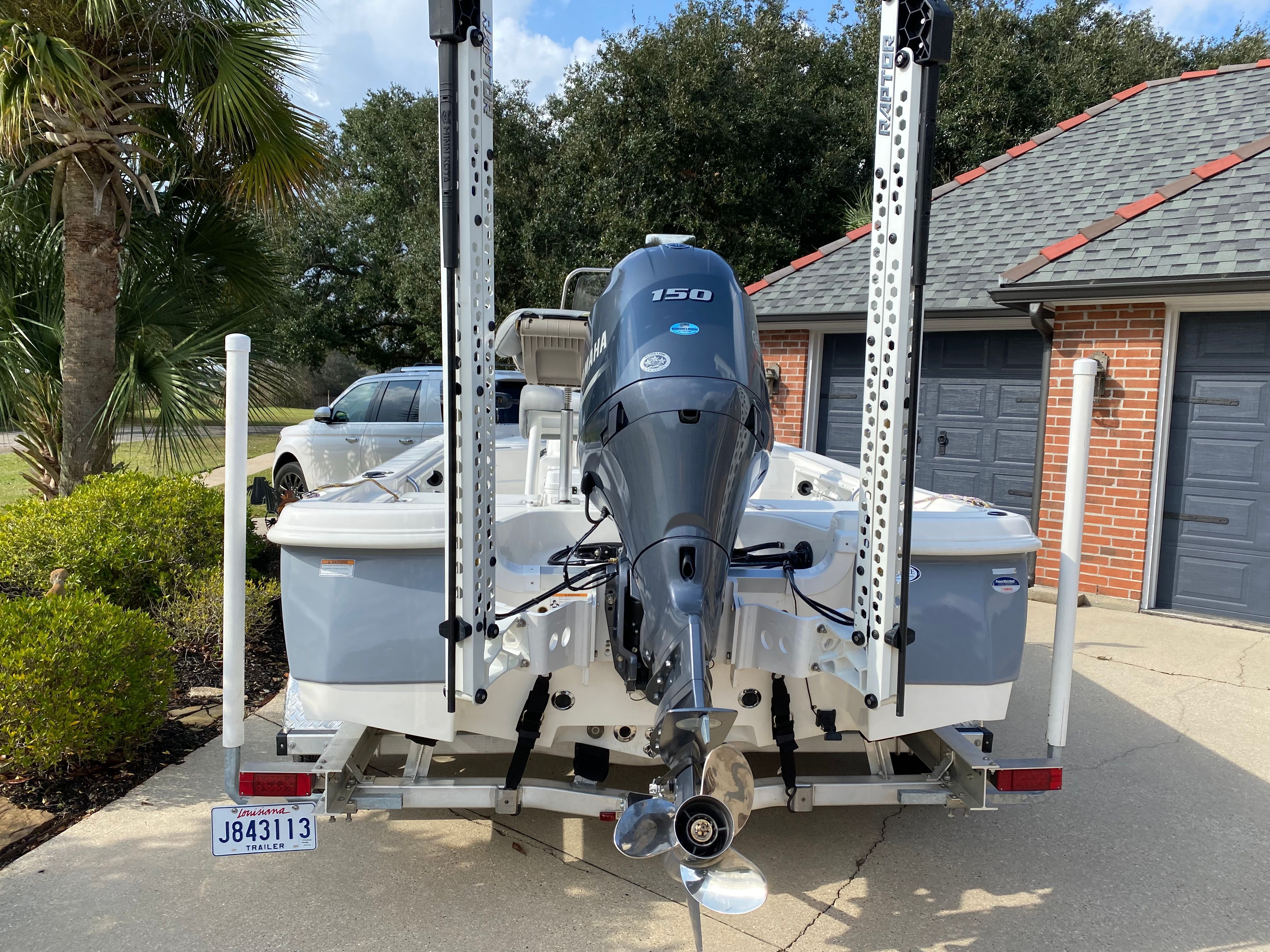 A 2021 NauticStar 195 XTS boat on a trailer in a driveway. It features a 150 HP outboard motor.