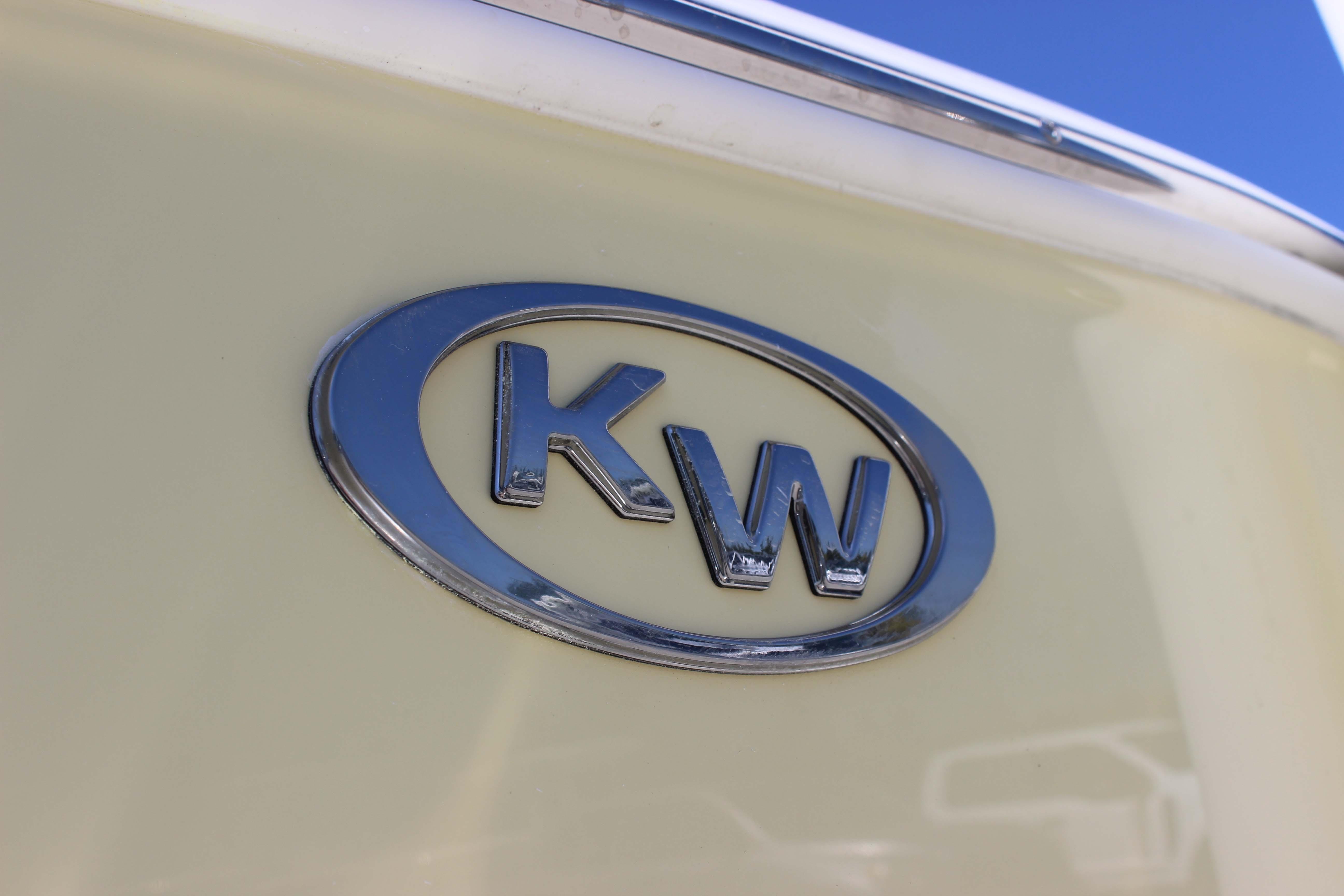 Chrome "KW" logo on 2026 Key West 203 FS boat against a light background.
