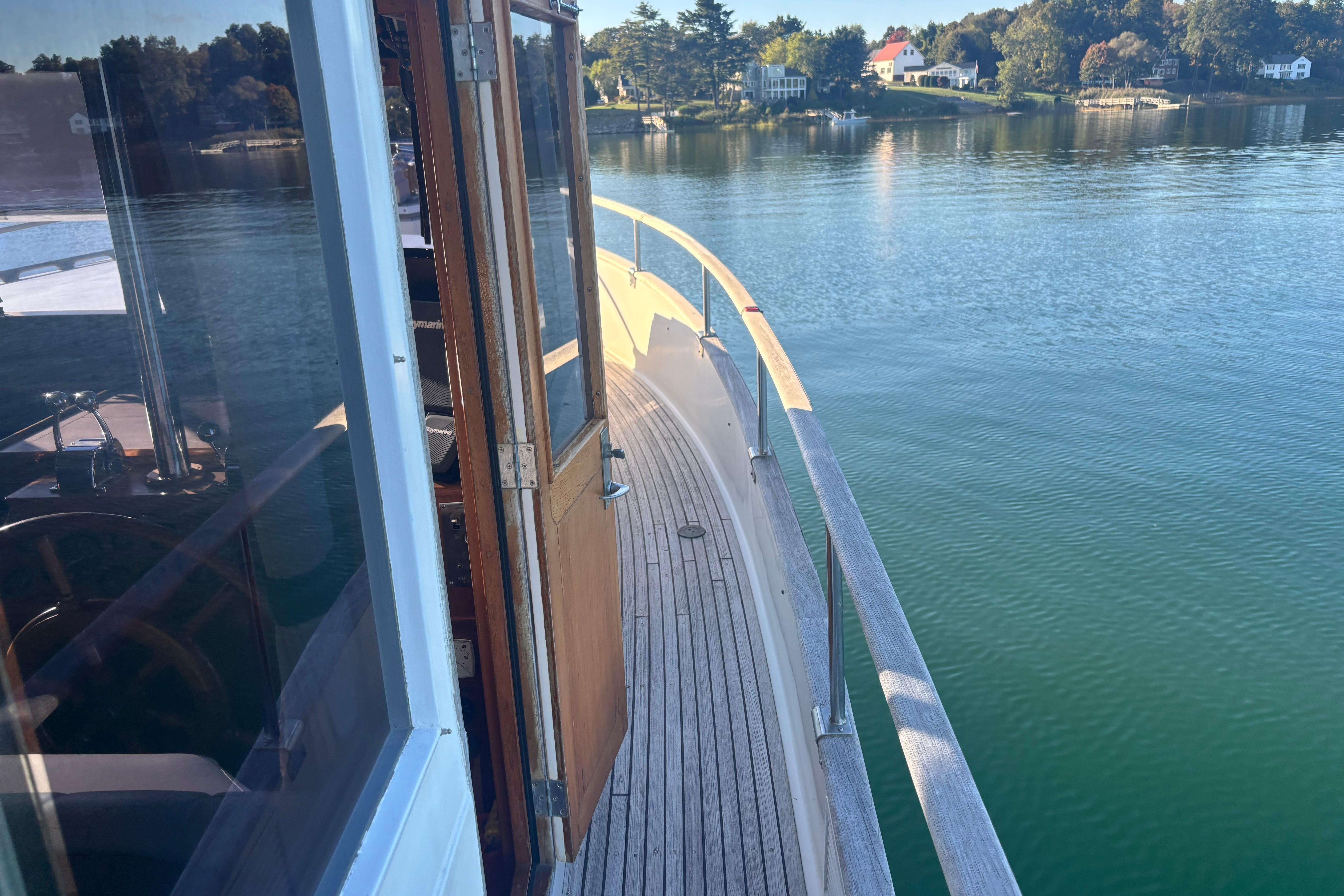 1989 Grand Banks 46 Classic yacht on calm water, showcasing wooden deck and serene surroundings.