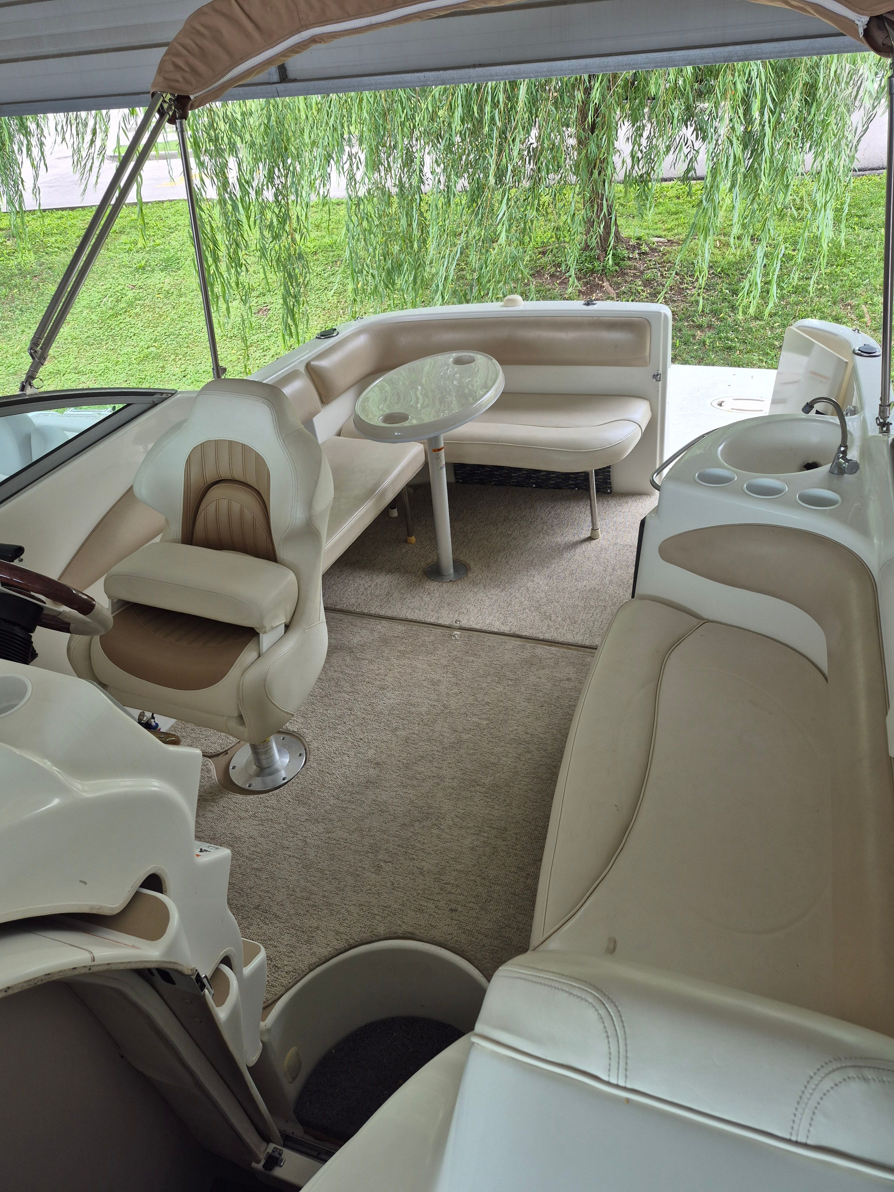 Interior of the 2004 Larson Cabrio 274 with beige seating and a table.