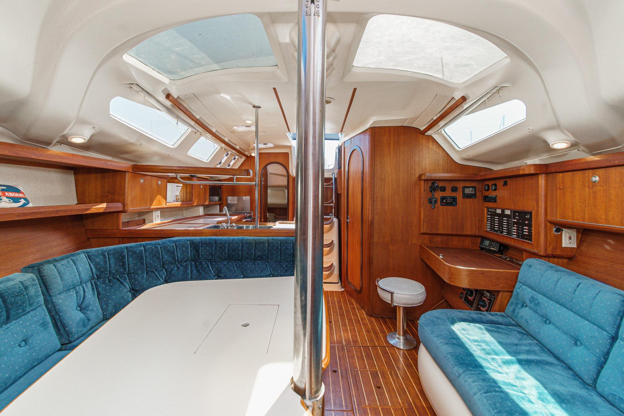 Interior of a 1996 Hunter 376 sailboat with wood finish and blue seating.