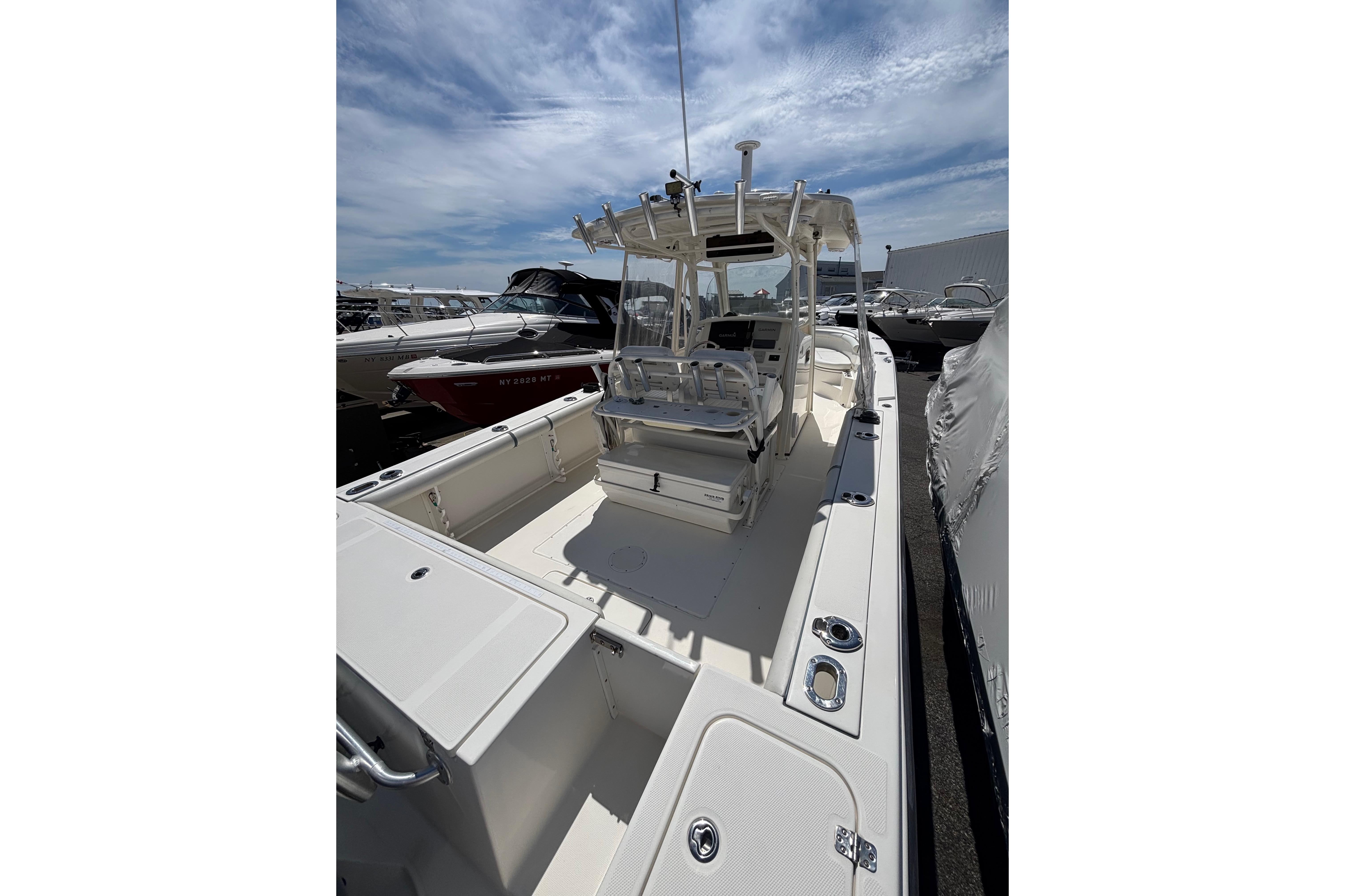 2006 Edgewater 318CC boat with spacious deck and modern helm, docked under a clear sky.