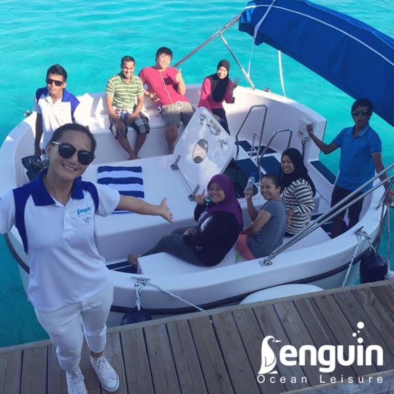 Group enjoying a ride on a 2025 Penguin Semi-Submarine 2.1 Gasoline in clear blue waters.