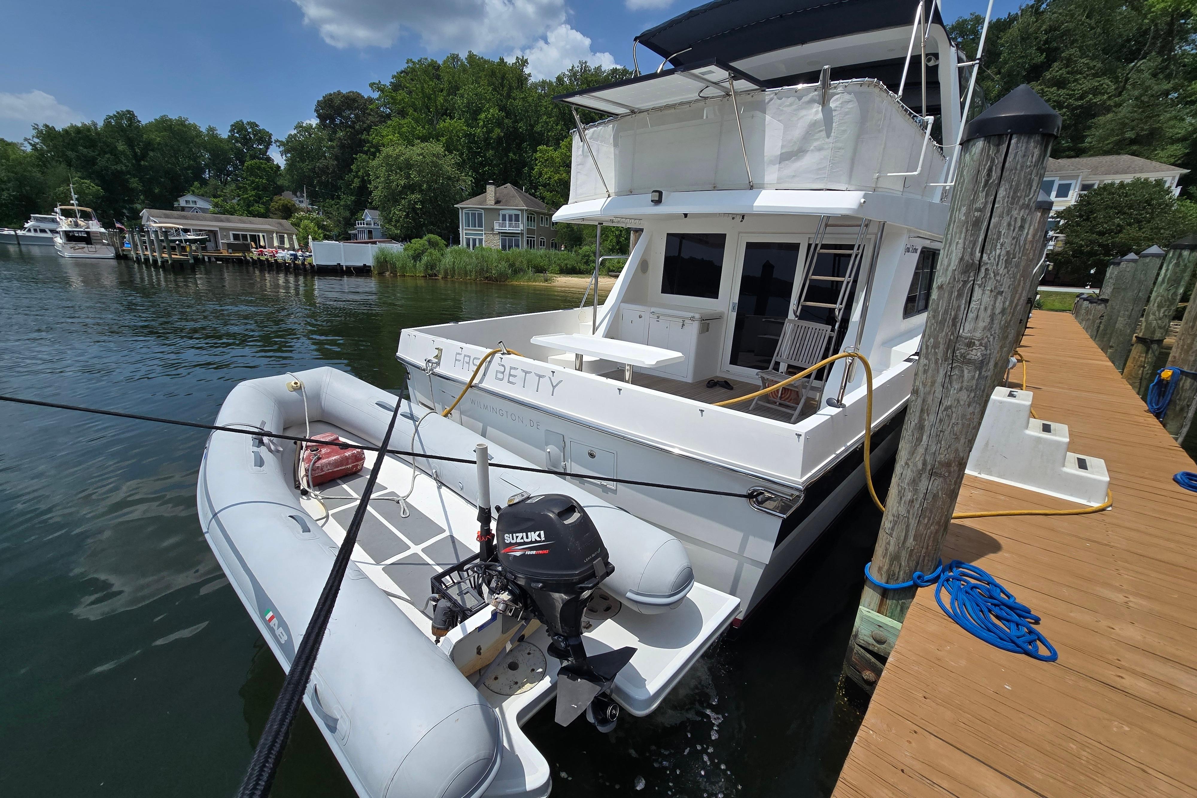 Grand Harbour 58 yacht from 2004 docked with inflatable boat and Suzuki motor.