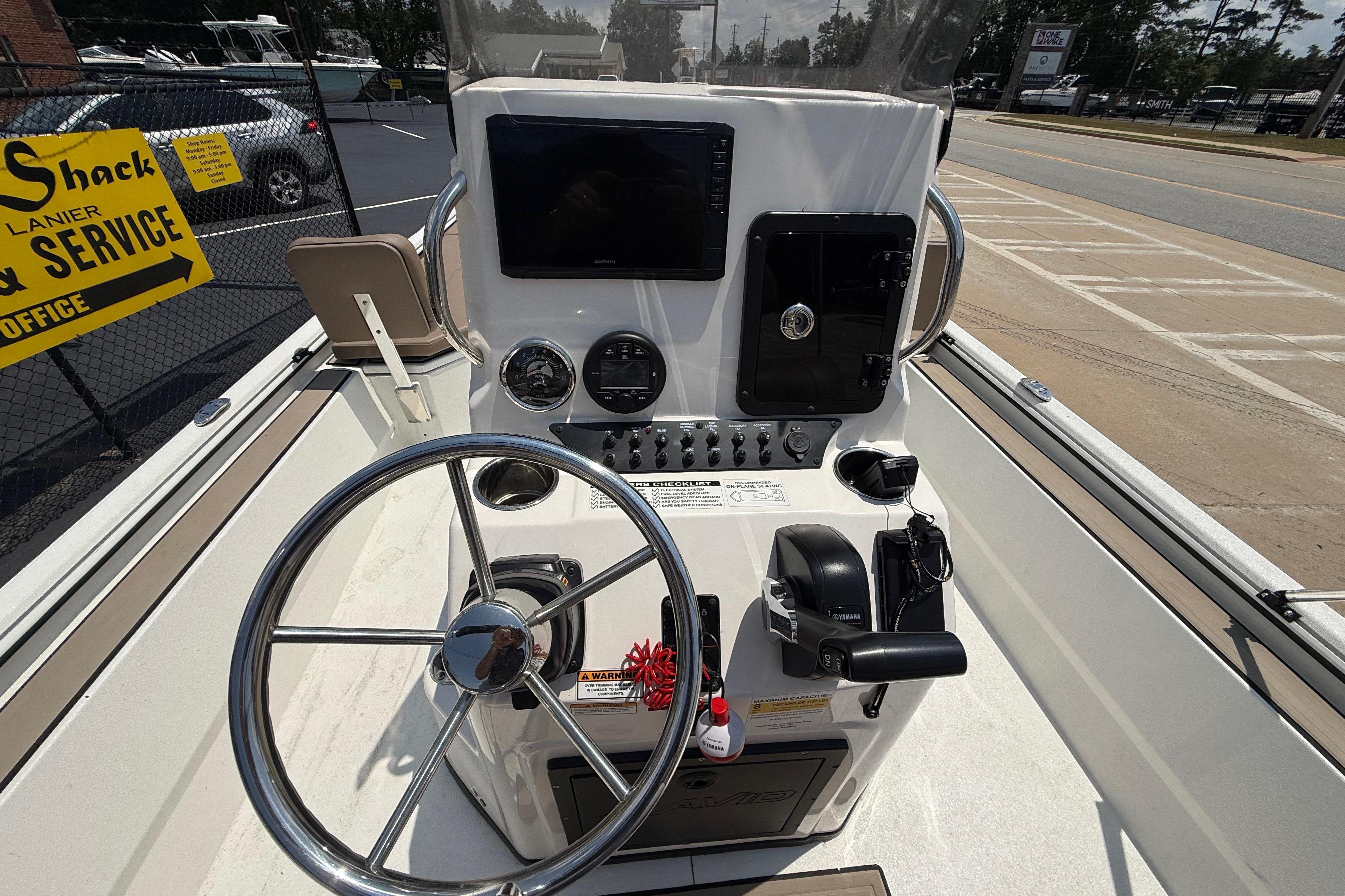 Center console of 2025 Avid 22 Recon boat with steering wheel and controls.
