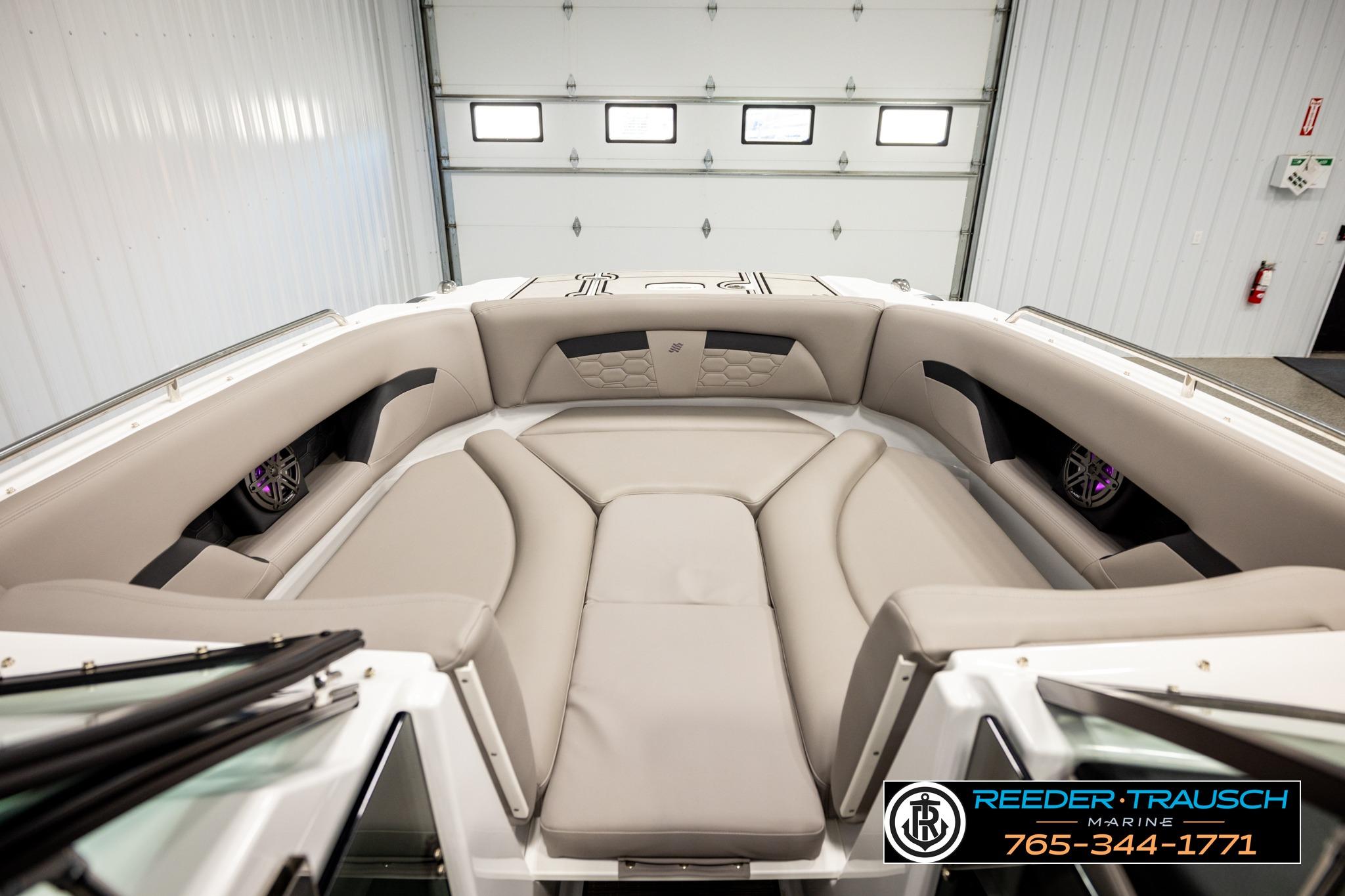 2024 FOURWINNS HD5 Surf boat interior with beige seating in a garage setting.