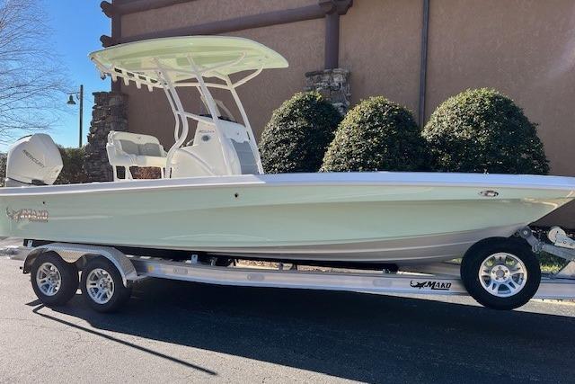 2026 Mako 24 APEX boat on trailer, parked outdoors, side view.