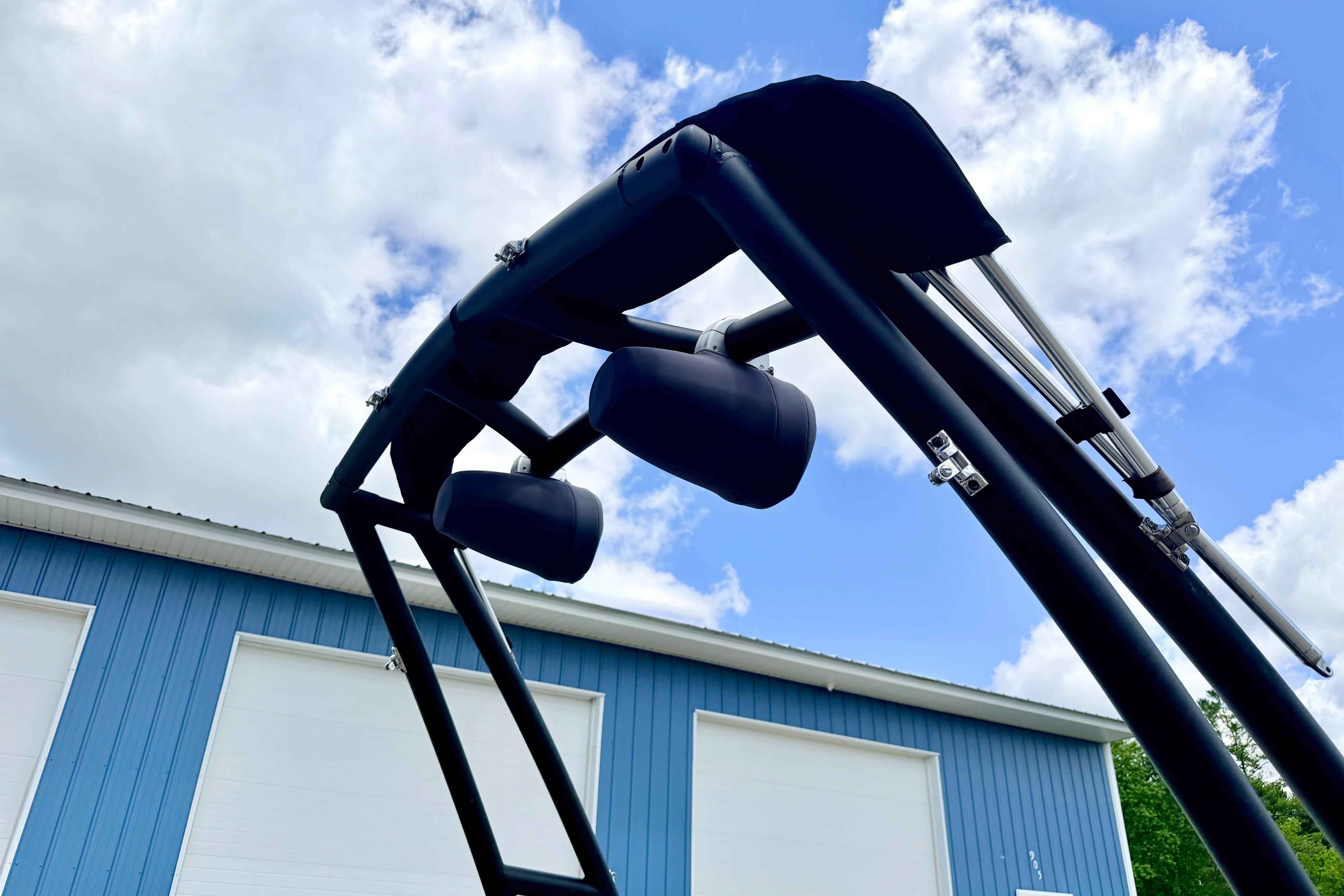 2018 Glastron GT 185 boat tower against blue sky and building background.