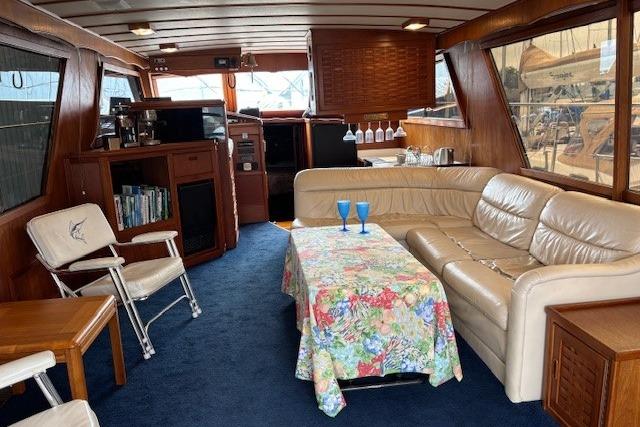 Interior of 1983 Canoe Cove Sedan Bridge with cozy seating and floral tablecloth.