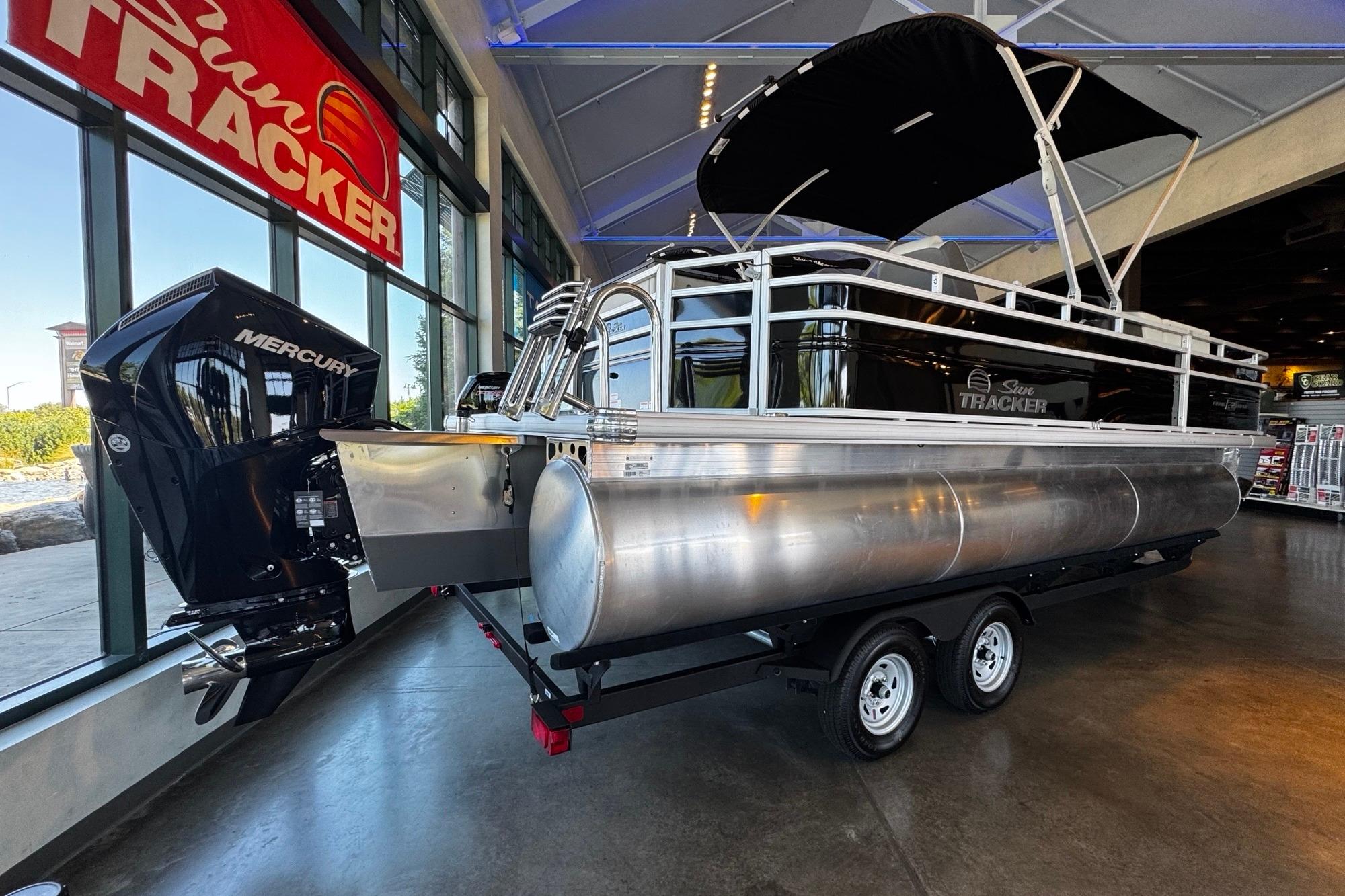 2026 Sun Tracker Fishin' Barge 22 XP3 pontoon boat displayed indoors.
