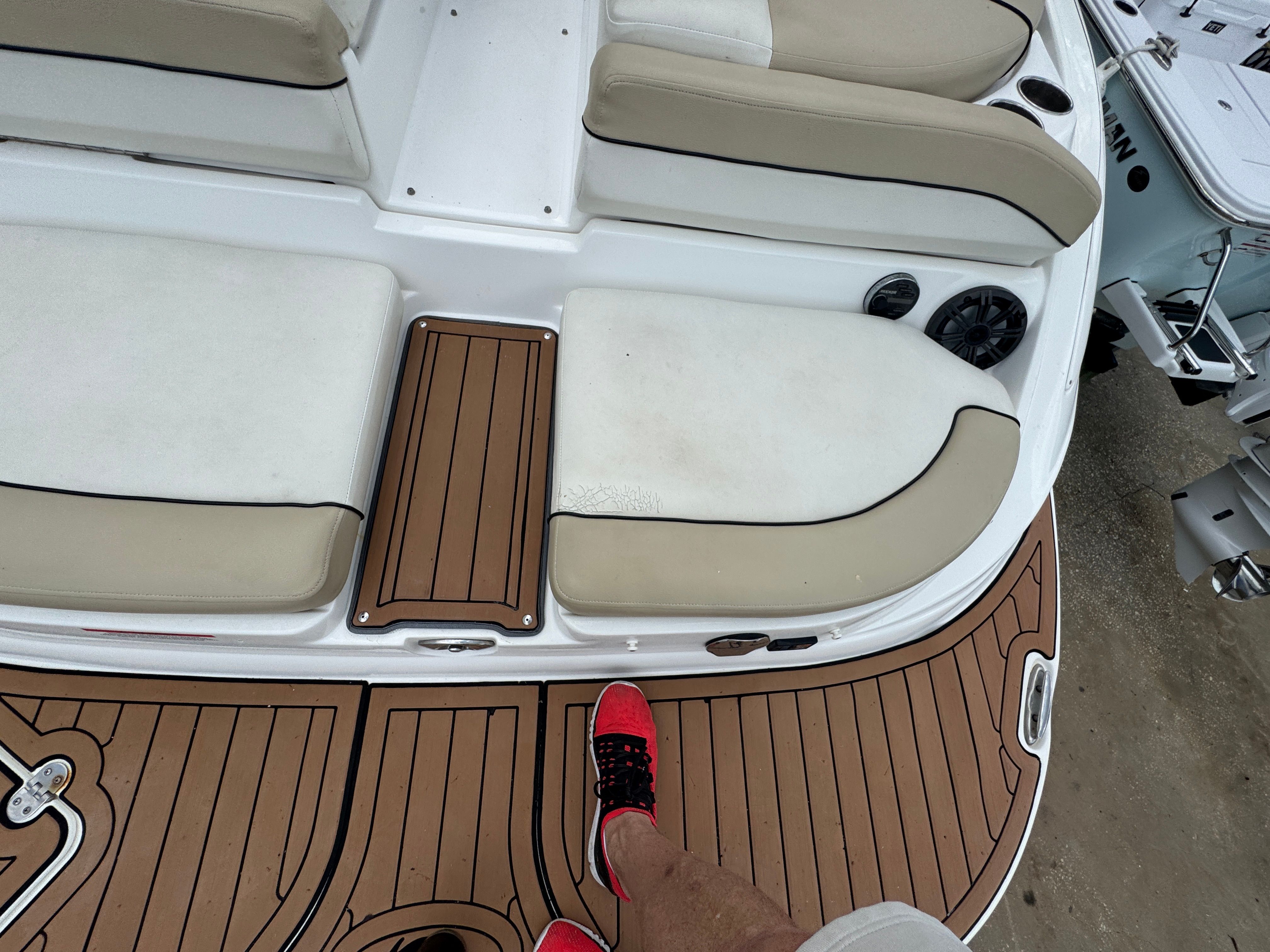 2017 Rinker QX29 BR boat with cushioned seats and wooden flooring.