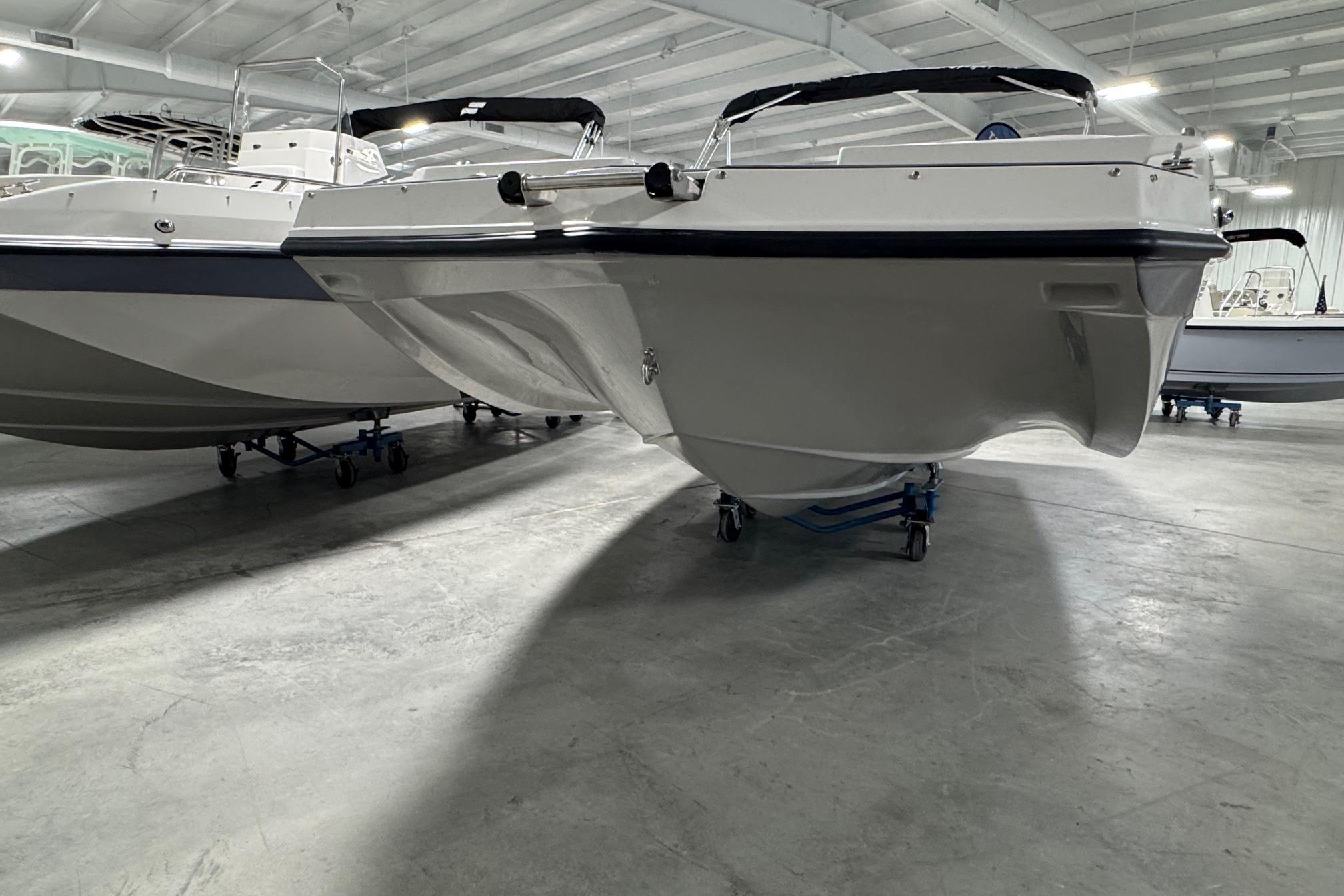 2026 Starcraft SVX 191 OB boat in showroom, side view, on wheeled supports.