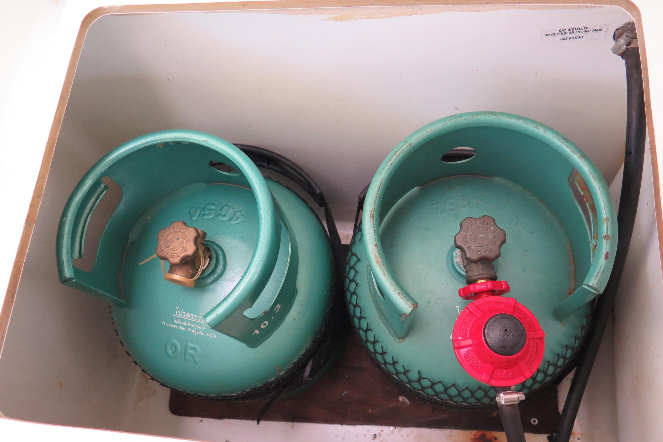 Two green gas cylinders in a storage compartment on a 2013 Foutaine Pajot Helia 44.