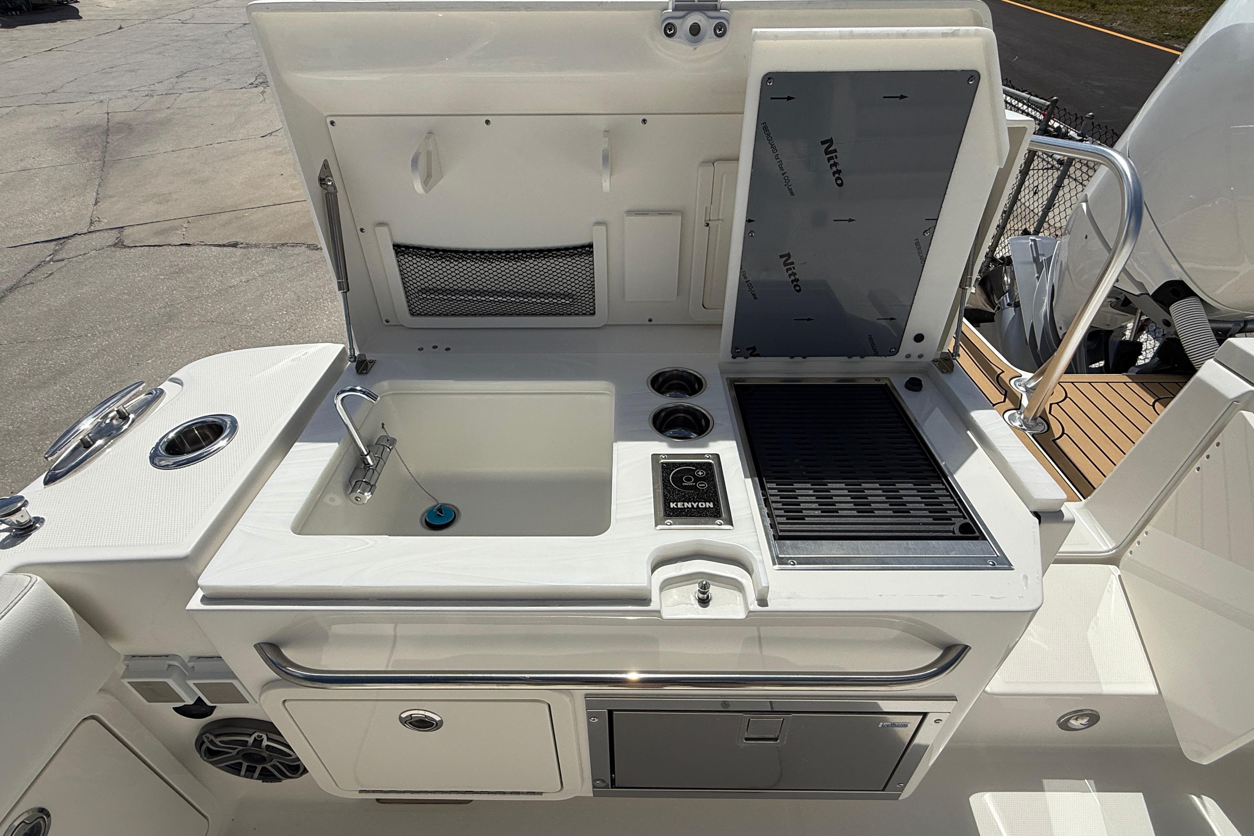 Outdoor kitchen on 2026 World Cat 400 DC-X Island boat with sink and grill.