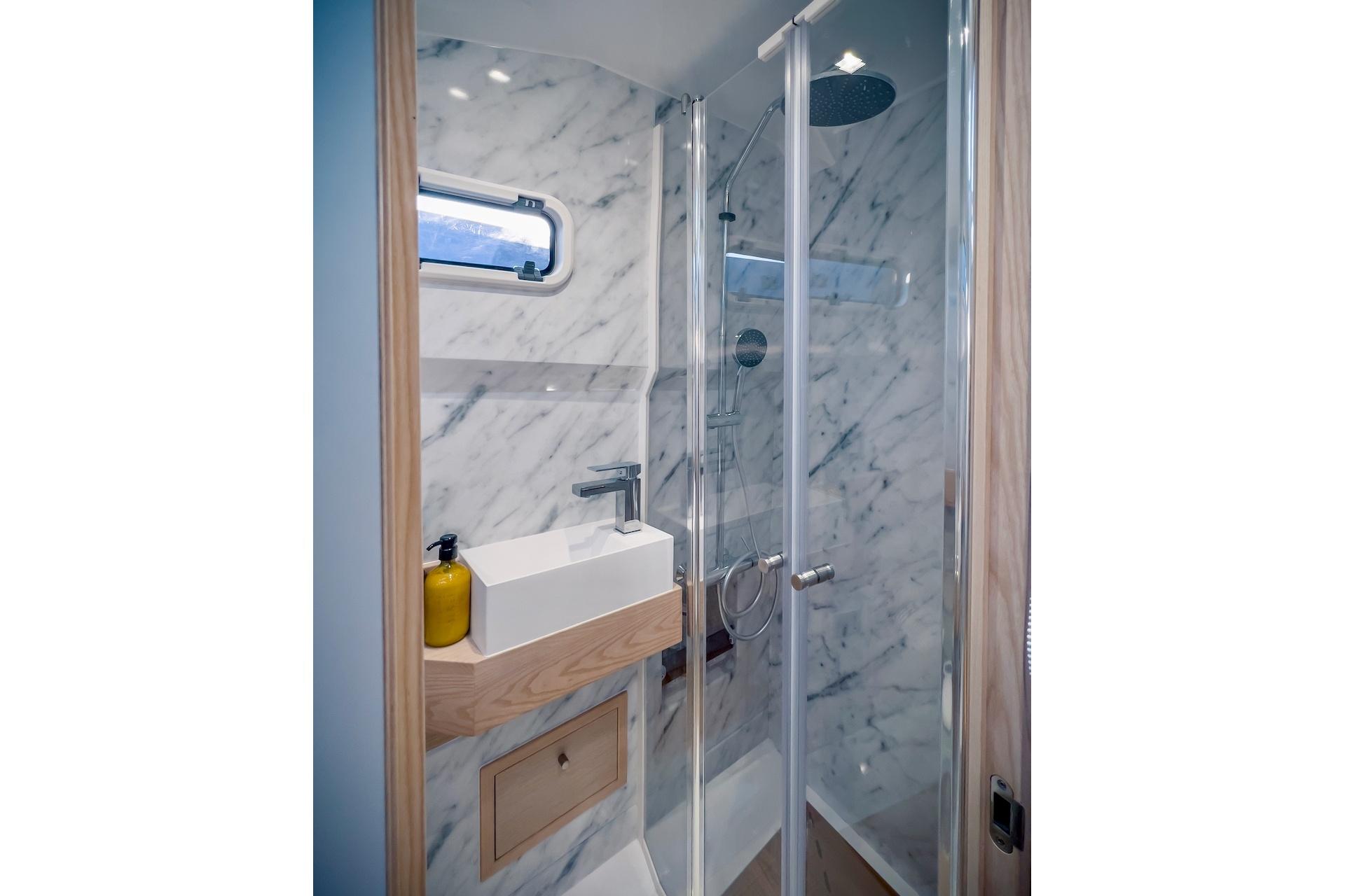 Luxurious bathroom in 2022 Tesoro T40 Inboard yacht with marble walls and modern fixtures.