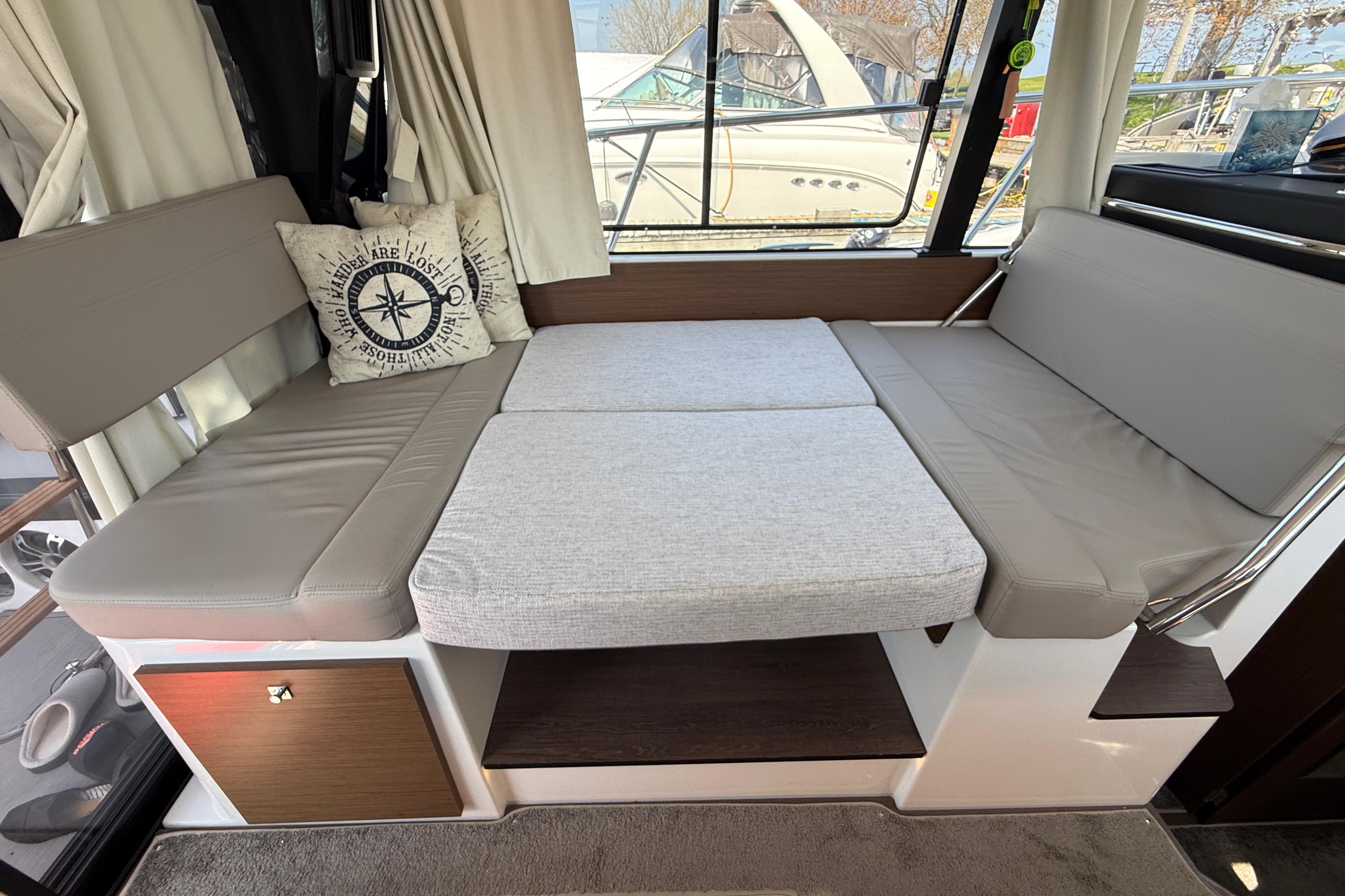 Interior of 2022 Jeanneau NC 1095 Fly with convertible seating and nautical-themed pillow.