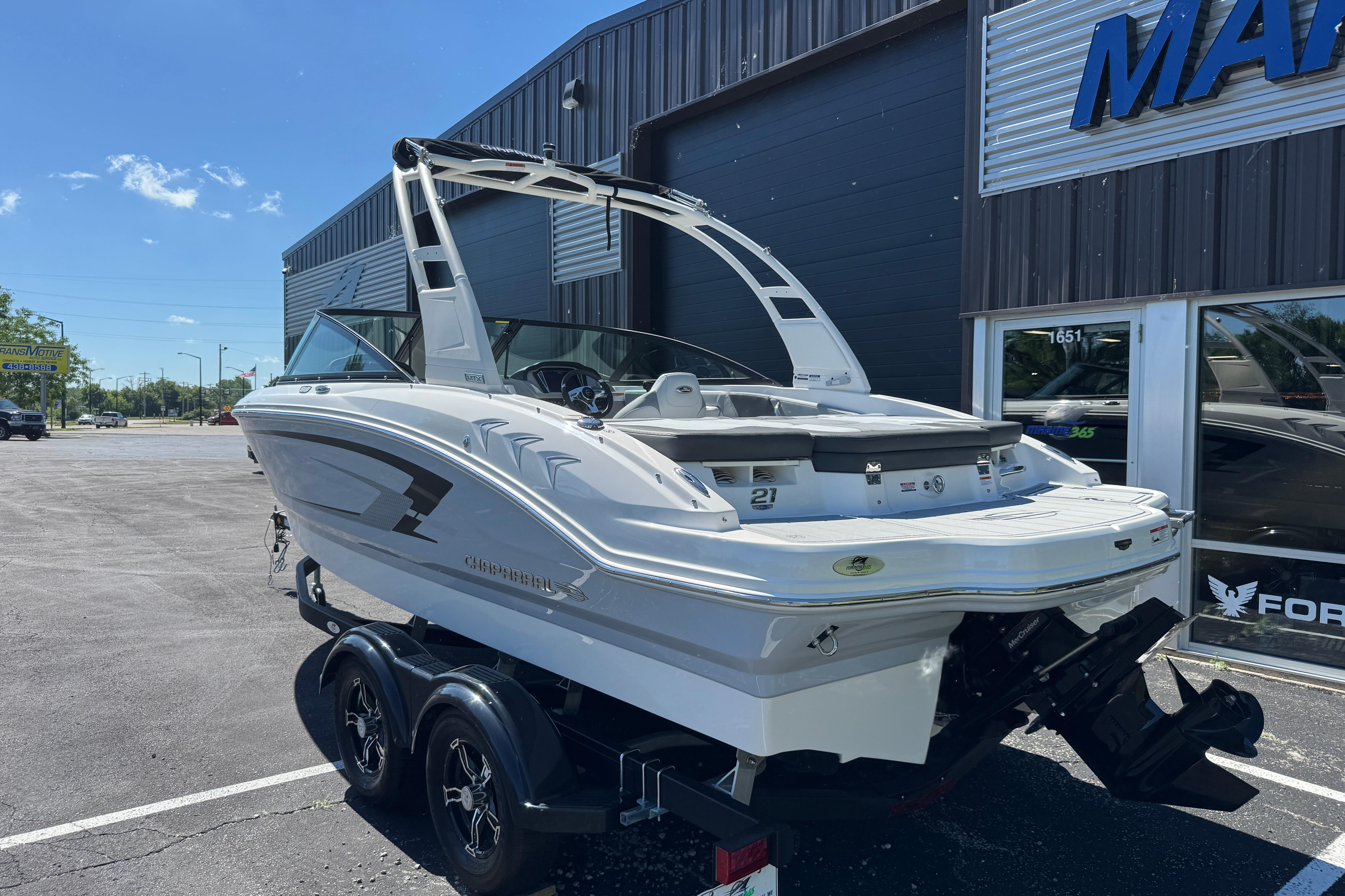 2026 Chaparral 21 SSi boat on trailer outside marine dealership, sunny day.