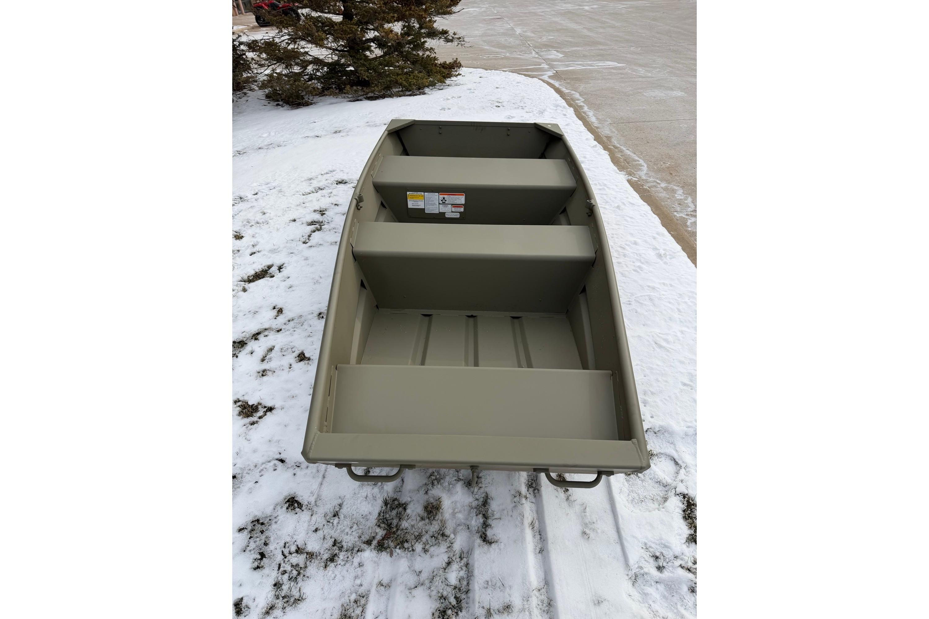 2026 Tracker Grizzly 10 Jon boat on snowy ground, showcasing interior seating and design.