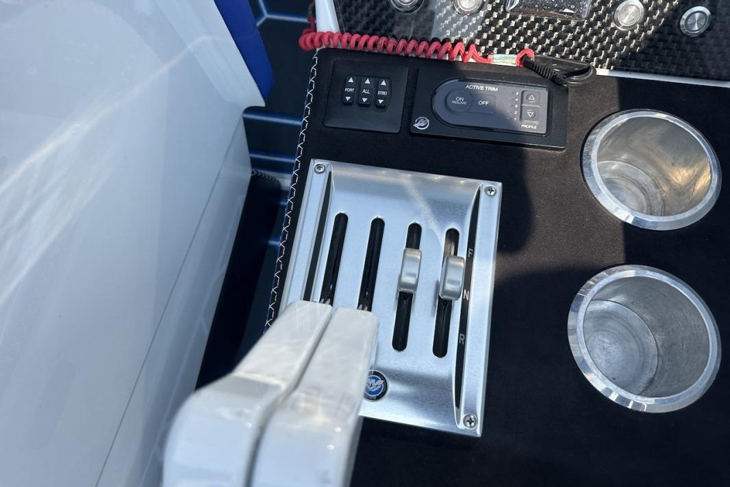 Control panel of 2018 Wright Performance 420 boat with throttle levers and cup holders.