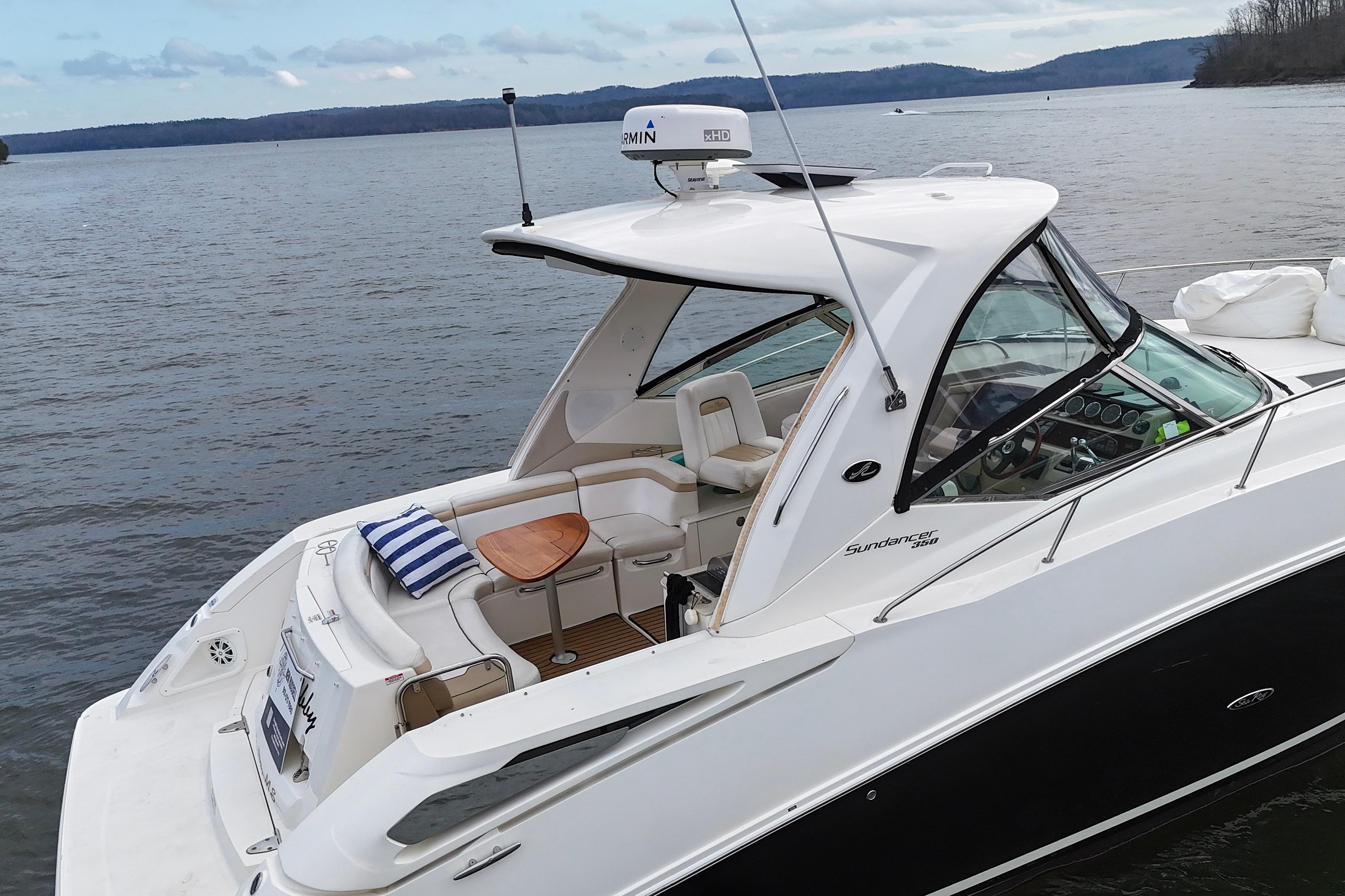 2009 Sea Ray Sundancer 350 yacht on calm lake with scenic background.