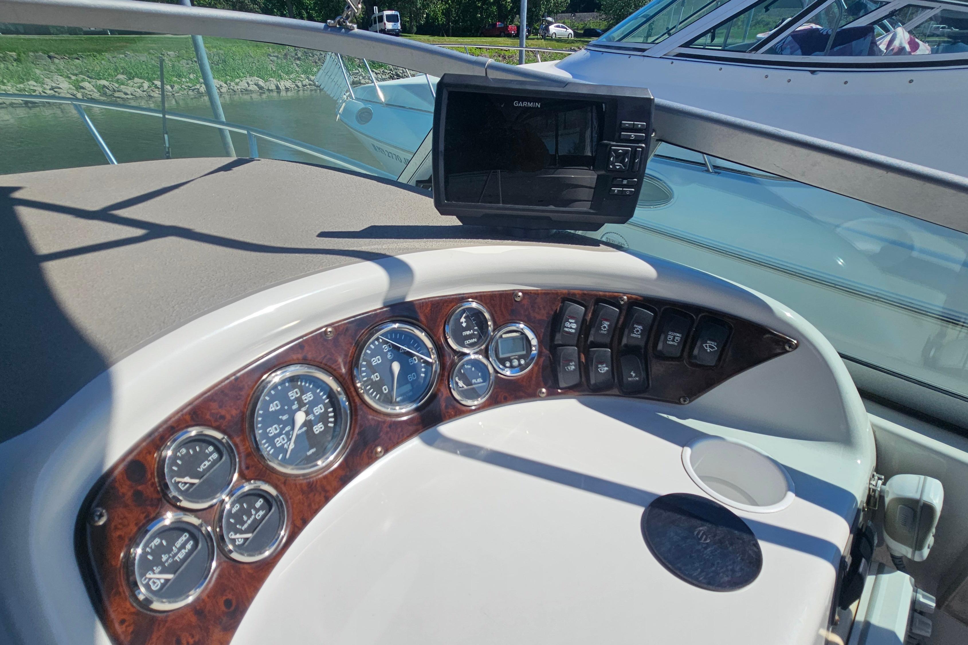 Dashboard of a 2000 Crownline 242 CR boat with gauges and Garmin device.