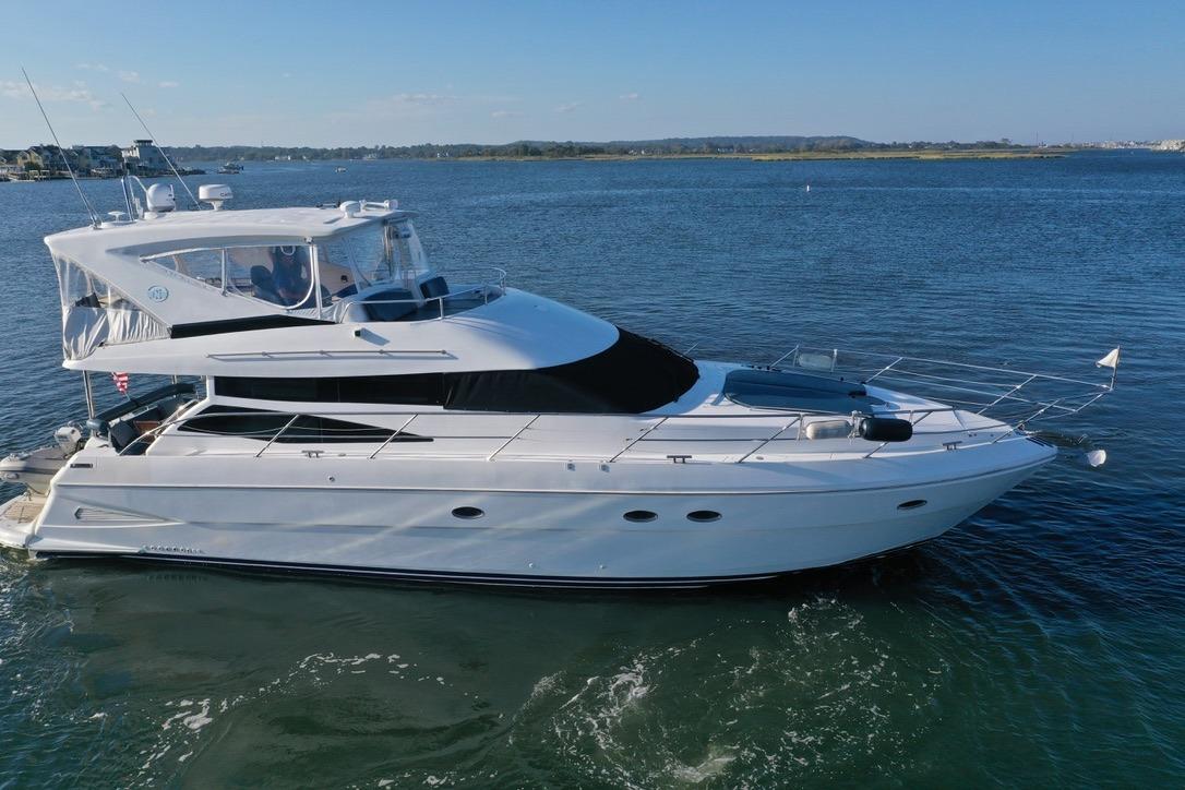 2005 Neptunus 56 Flybridge yacht cruising on calm waters under clear skies.