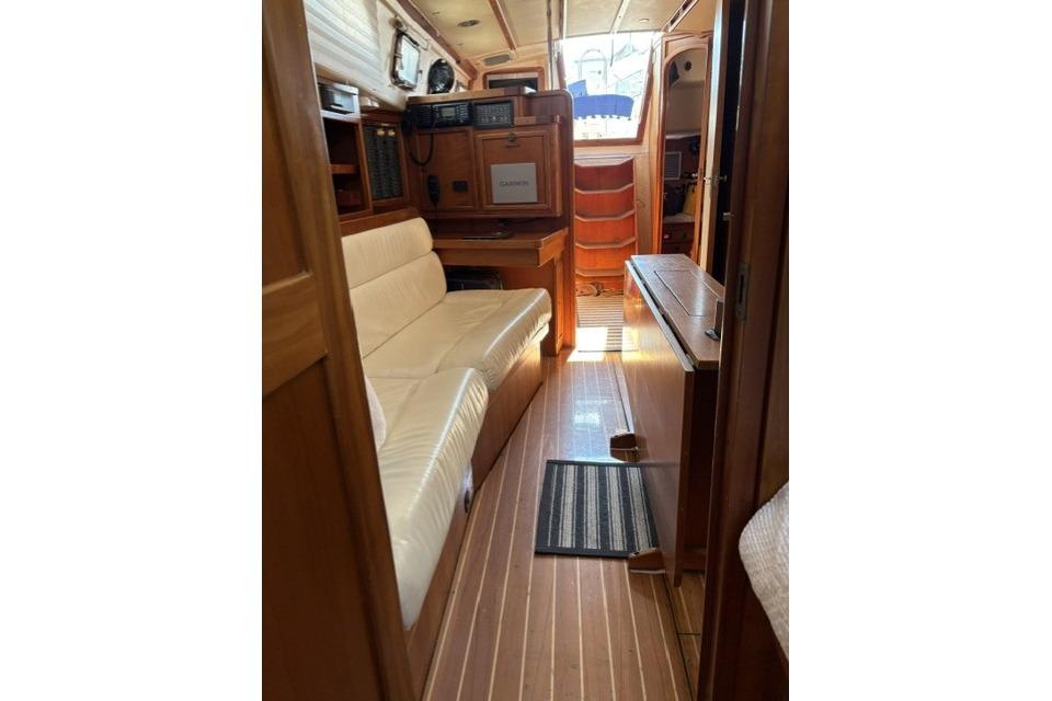Interior of 2002 Saga 43 yacht with wooden flooring and comfortable seating.