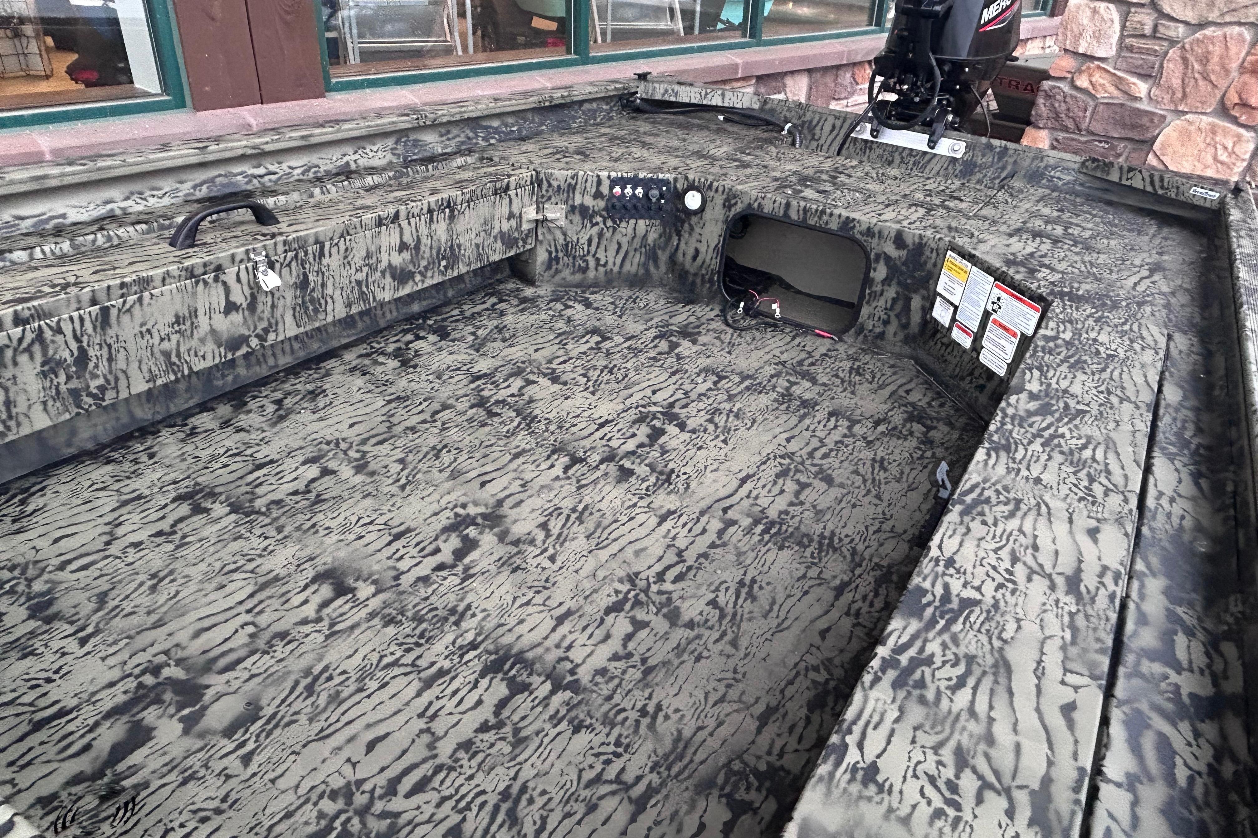 2026 Tracker Grizzly 1654 T Sportsman boat interior with camouflage design and storage compartments.