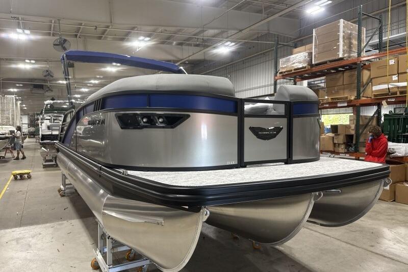 2026 Bennington 23 LXS Swingback pontoon boat in a warehouse setting.