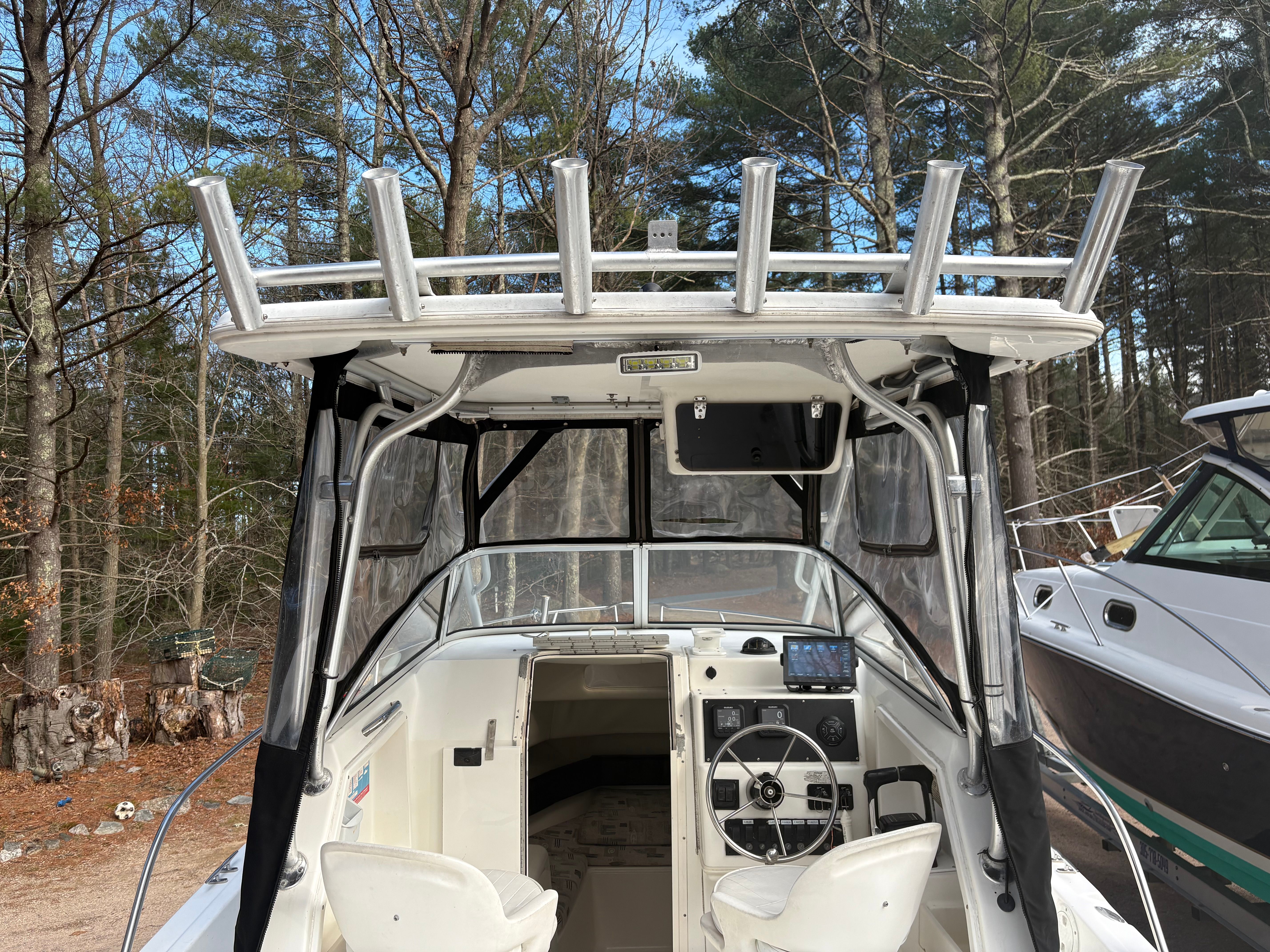 Spacecraft Cuddy 2000 boat with helm in wooded area.