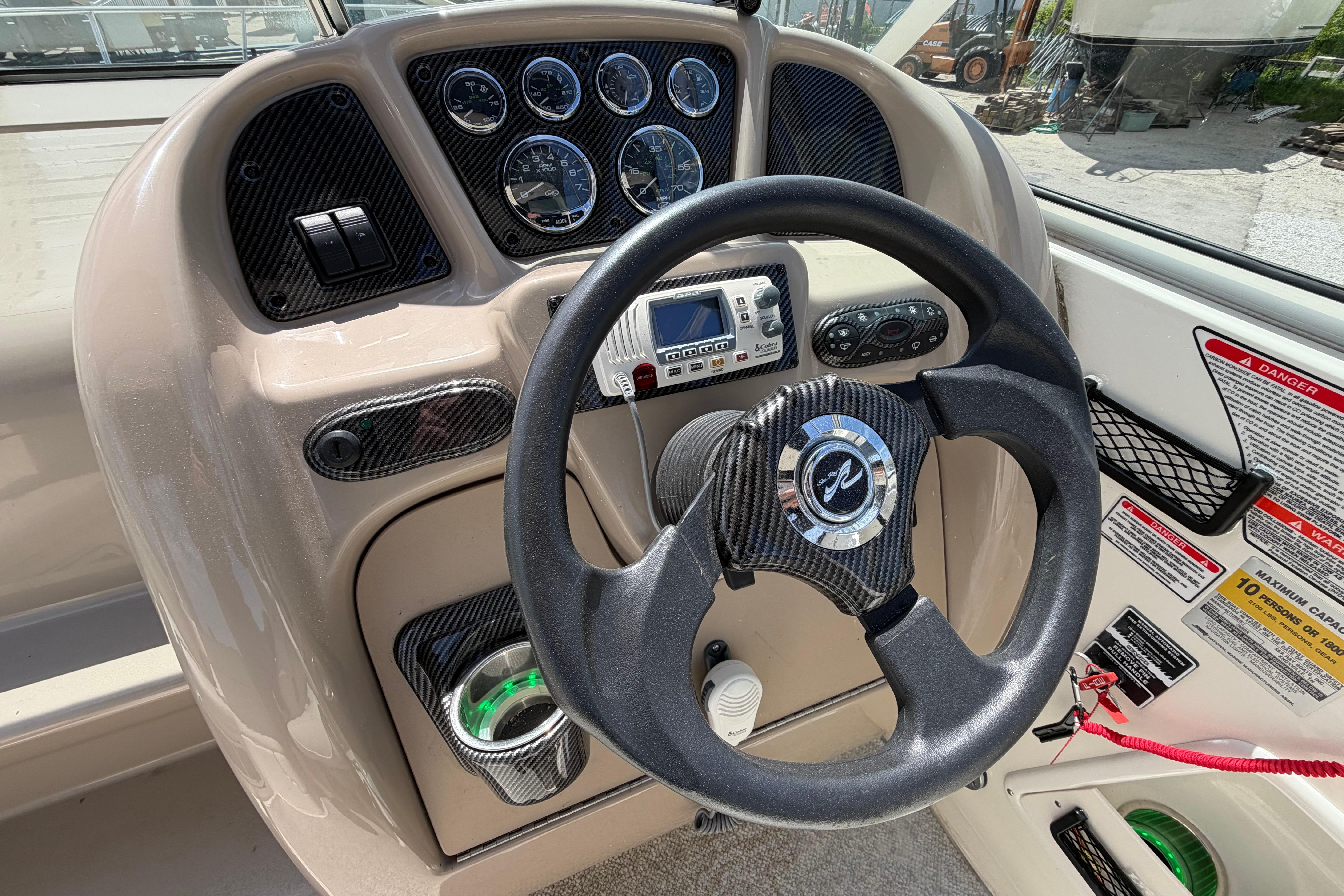 Steering console of a 2004 Sea Ray Sundancer 260 boat with gauges and controls.