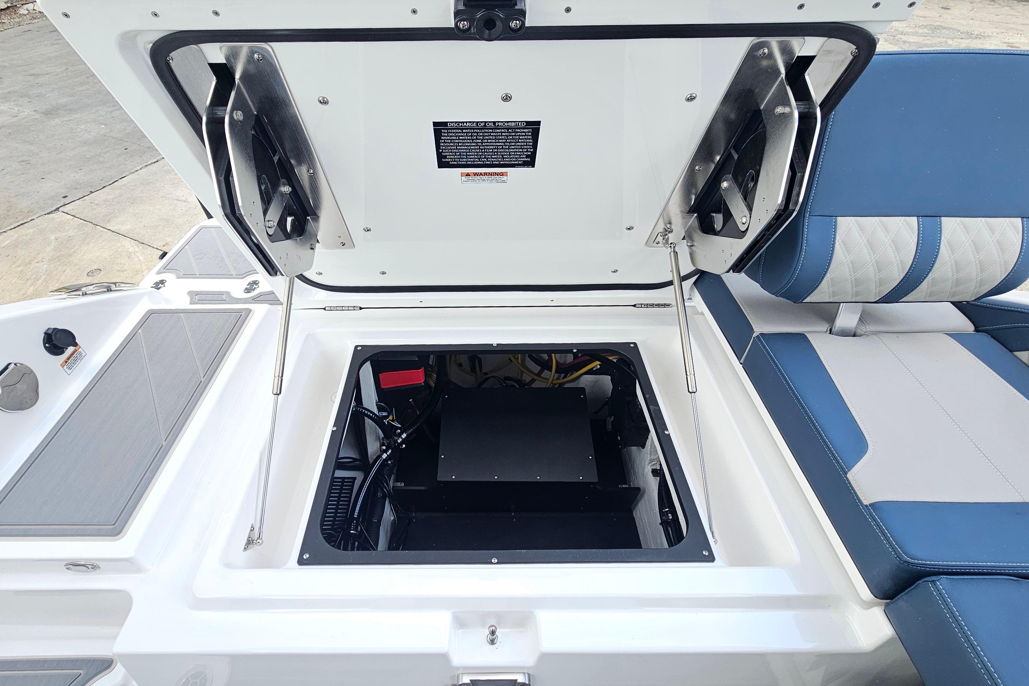 Open engine compartment of 2026 Monterey Elite 27 OB boat with blue seating.