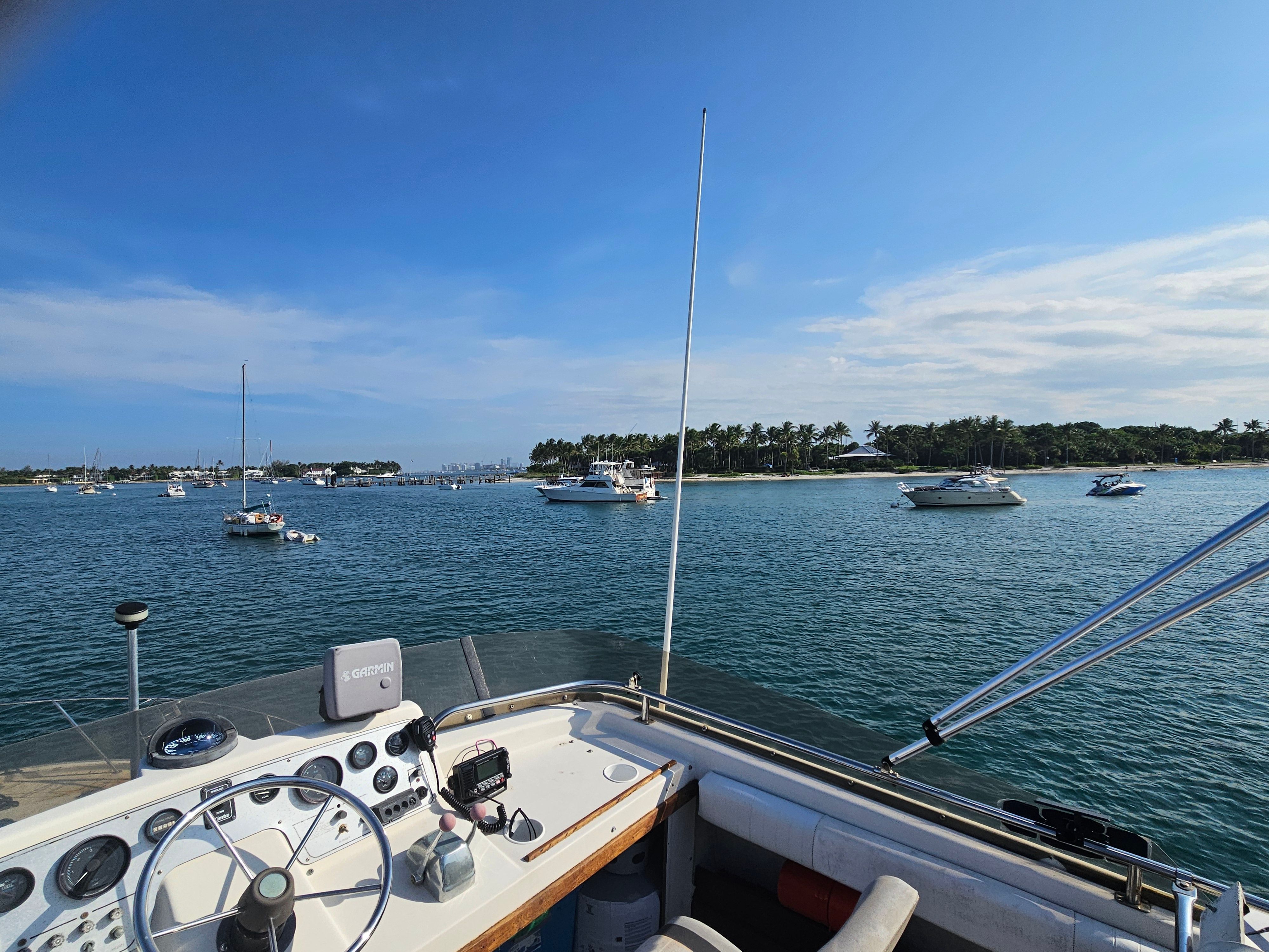 A 1984 Silverton 40 boat on calm water with other boats in the distance.
