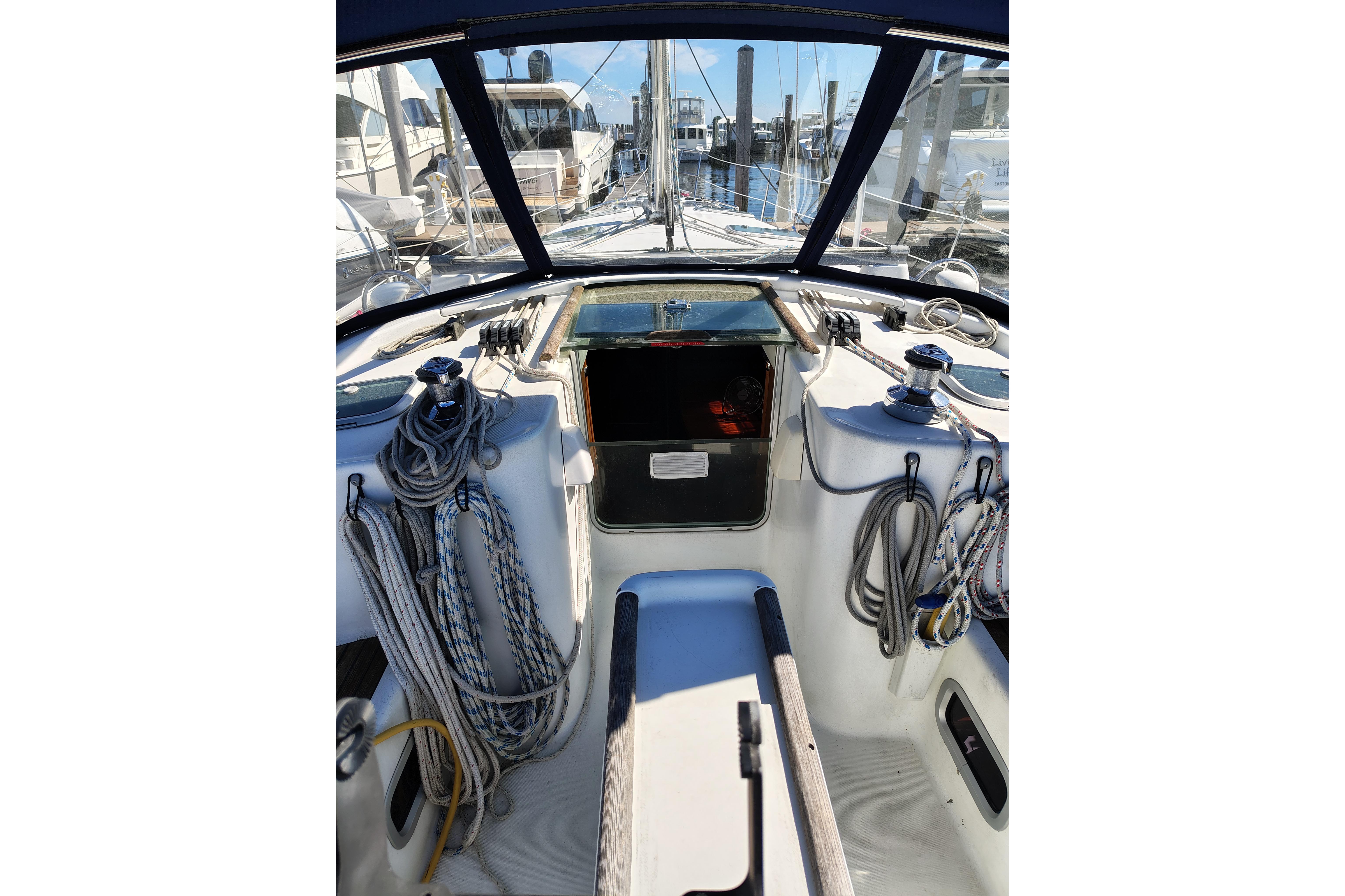 Cockpit view of 2001 Beneteau Oceanis 411 sailboat, featuring ropes and winches.