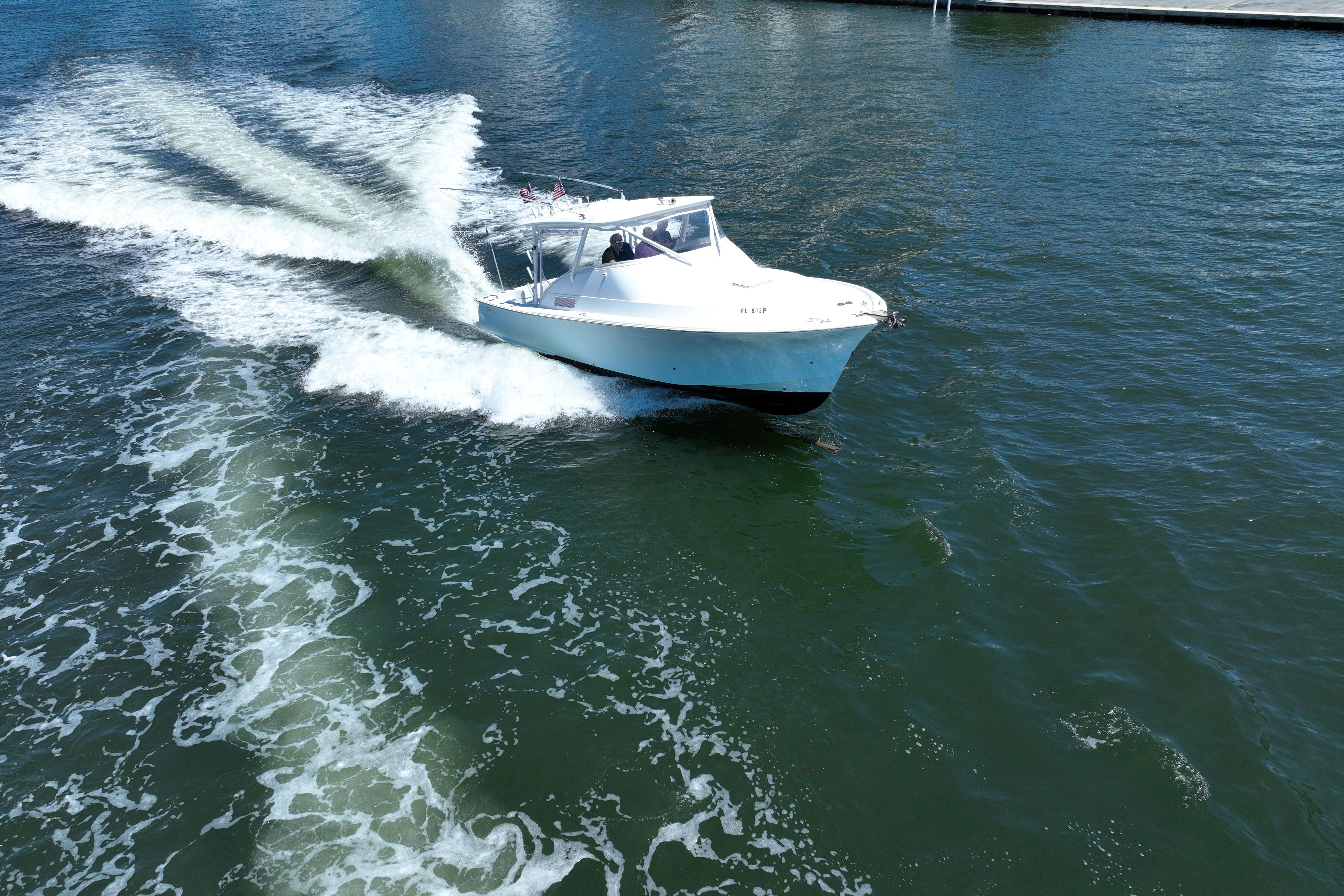 2012 Custom Carolina 34 boat cruising on open water, creating a wake.