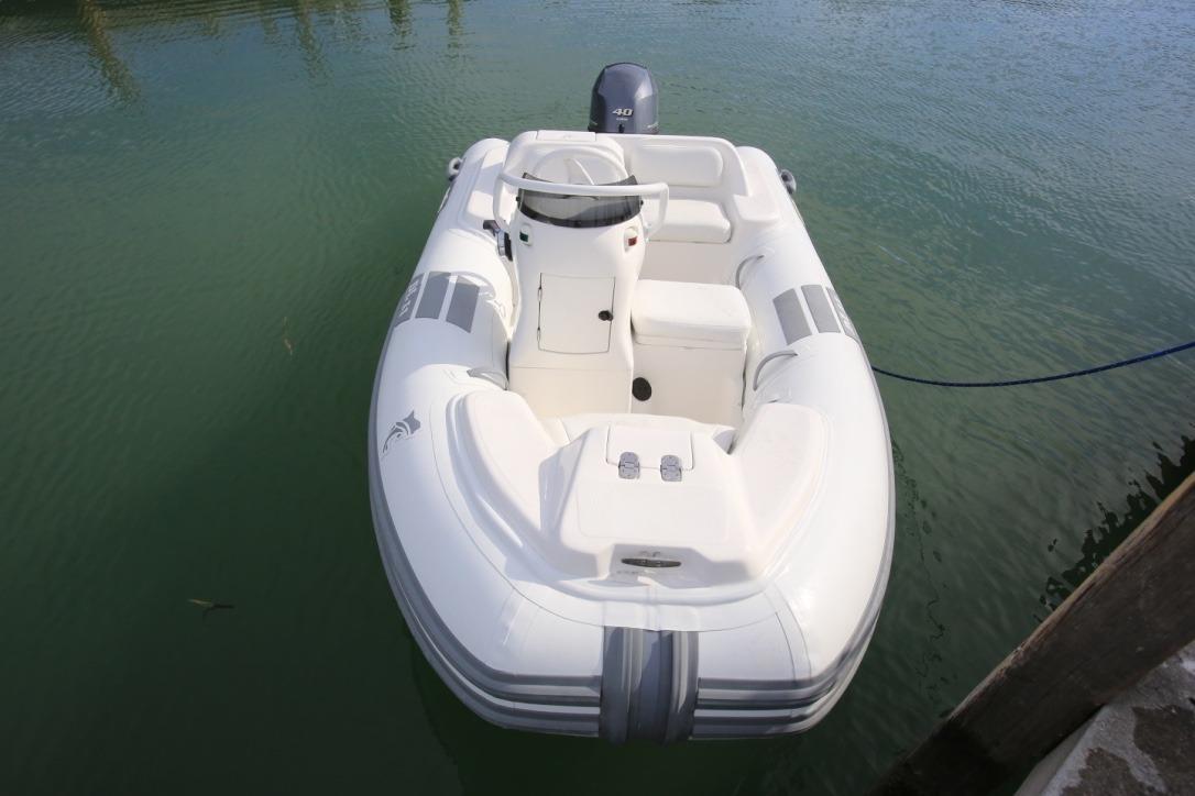 2025 Caribe DL11 inflatable boat docked on calm water.