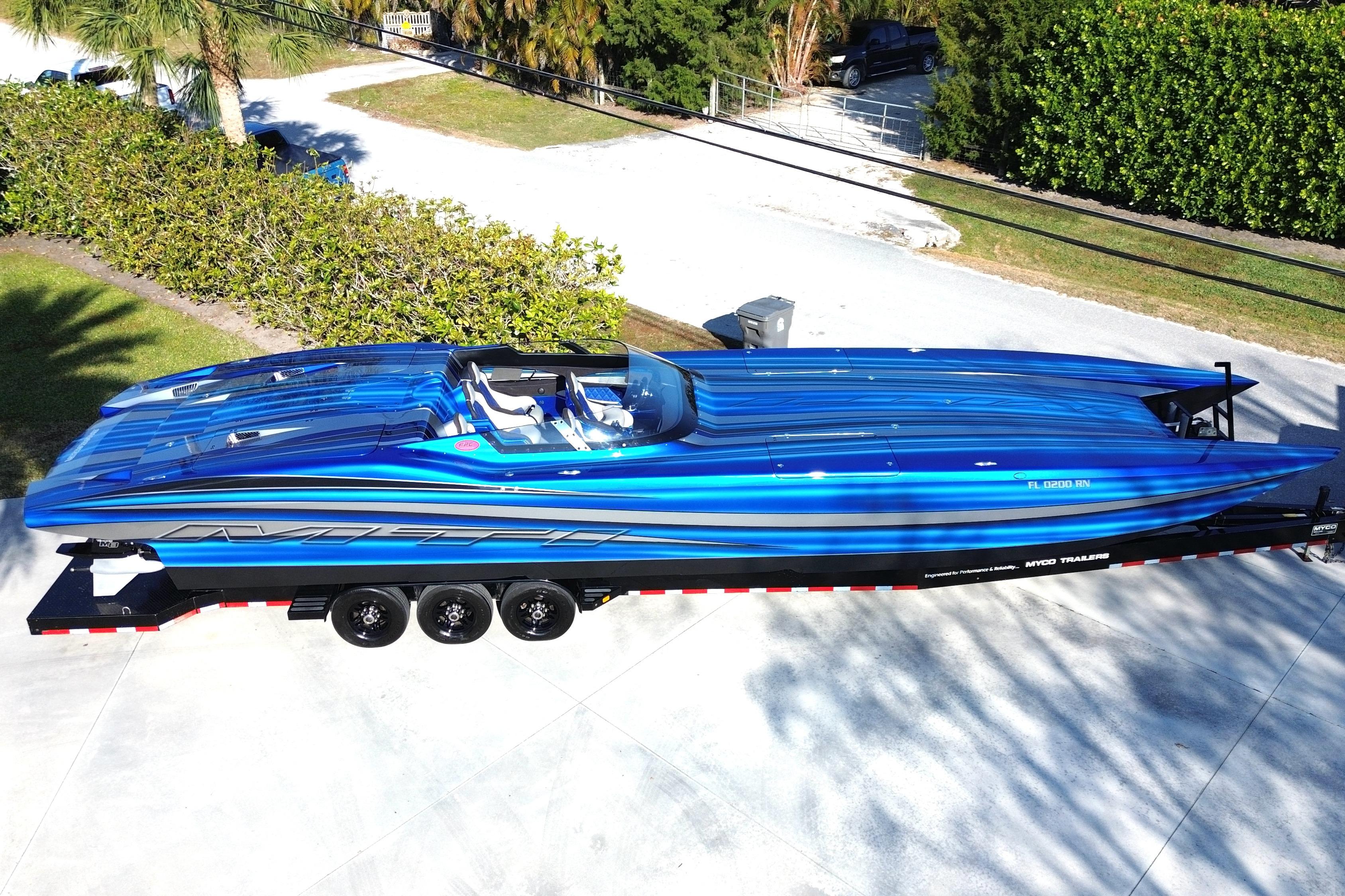 2016 MTI 44 RP speedboat in vibrant blue on a trailer, parked outdoors.