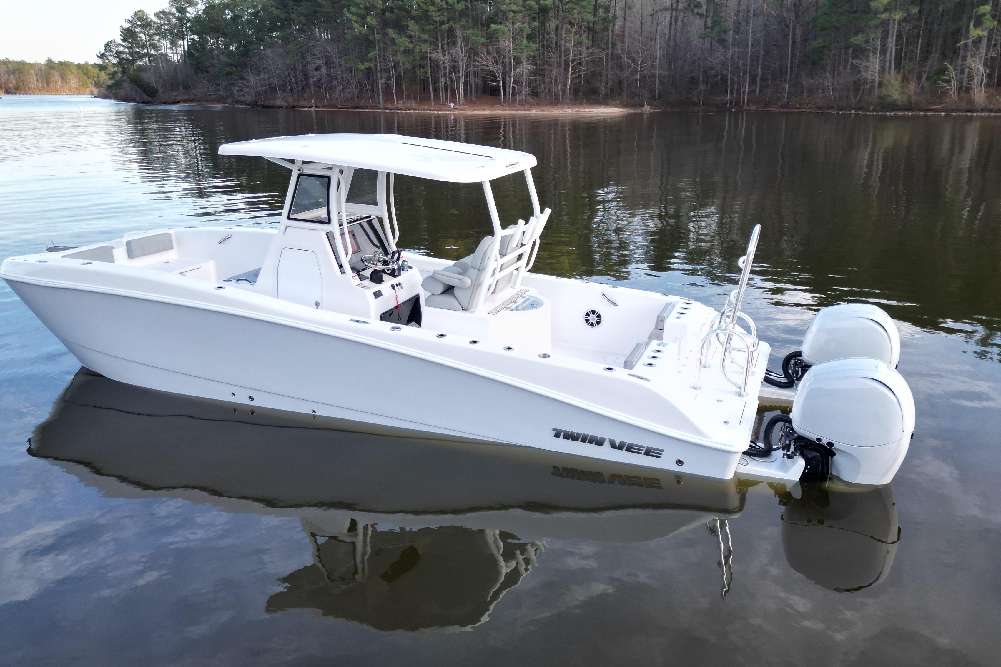 2023 Twin Vee 260 GFX CC boat on calm lake, featuring dual engines and sleek design.