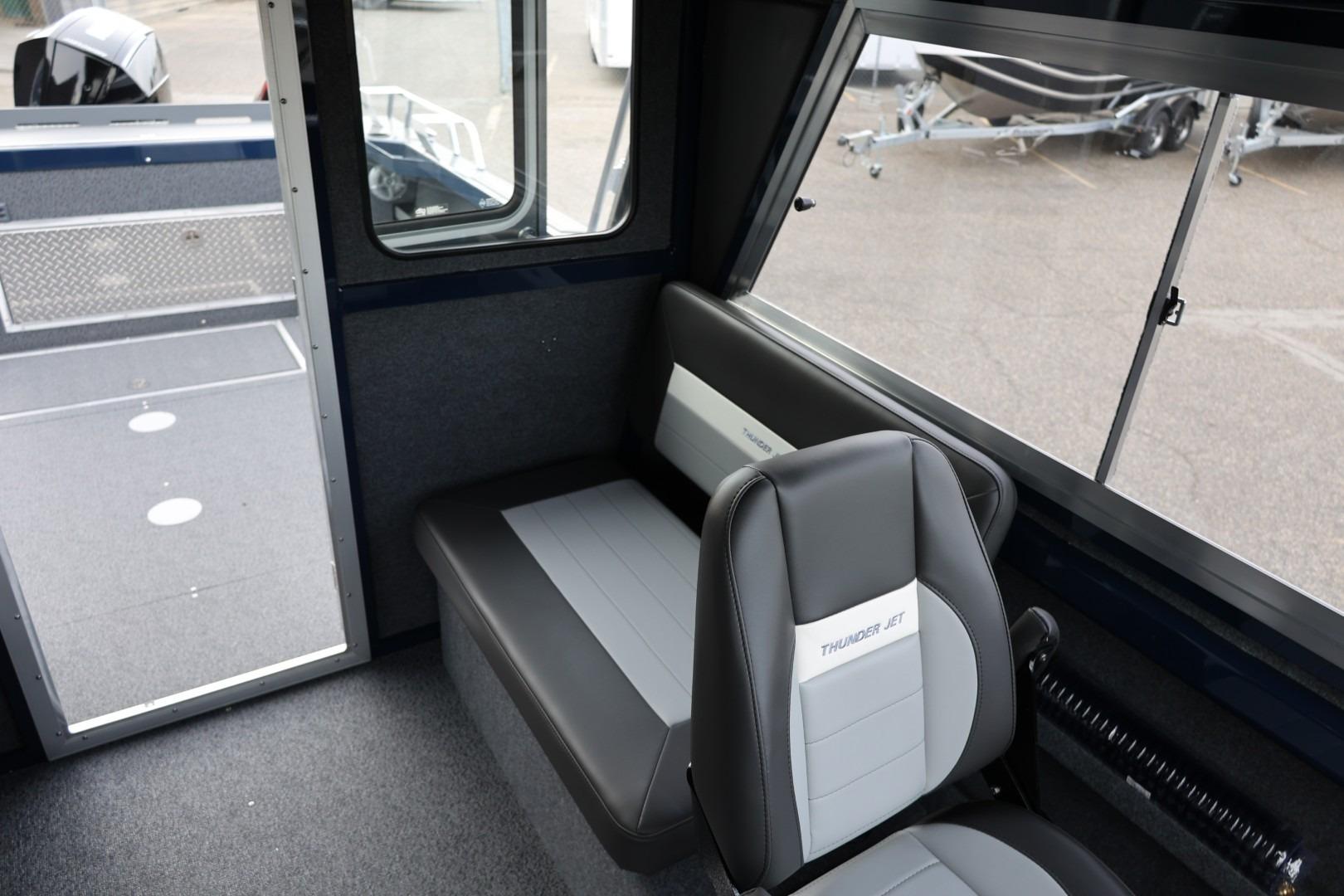 Interior of 2026 Thunder Jet 24 Alexis Pro boat, featuring seating and window view.