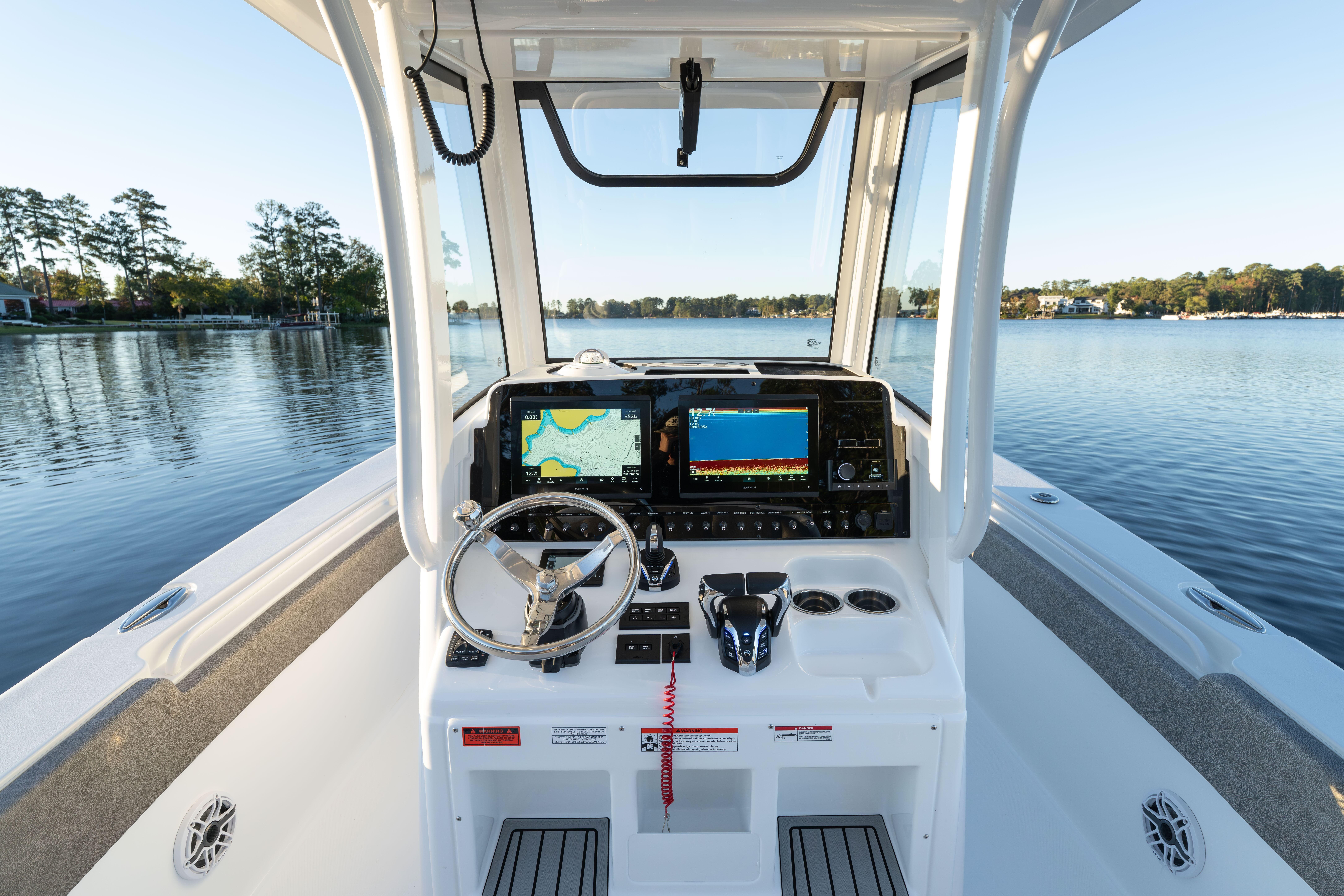 2026 Sea Hunt Ultra 275 Coffin Box boat dashboard with navigation screens on a serene lake.