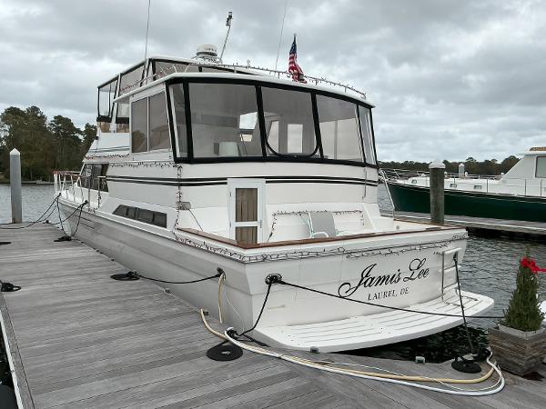 Novatec Islander 55 yacht docked, 2000 model, with American flag and festive lights.