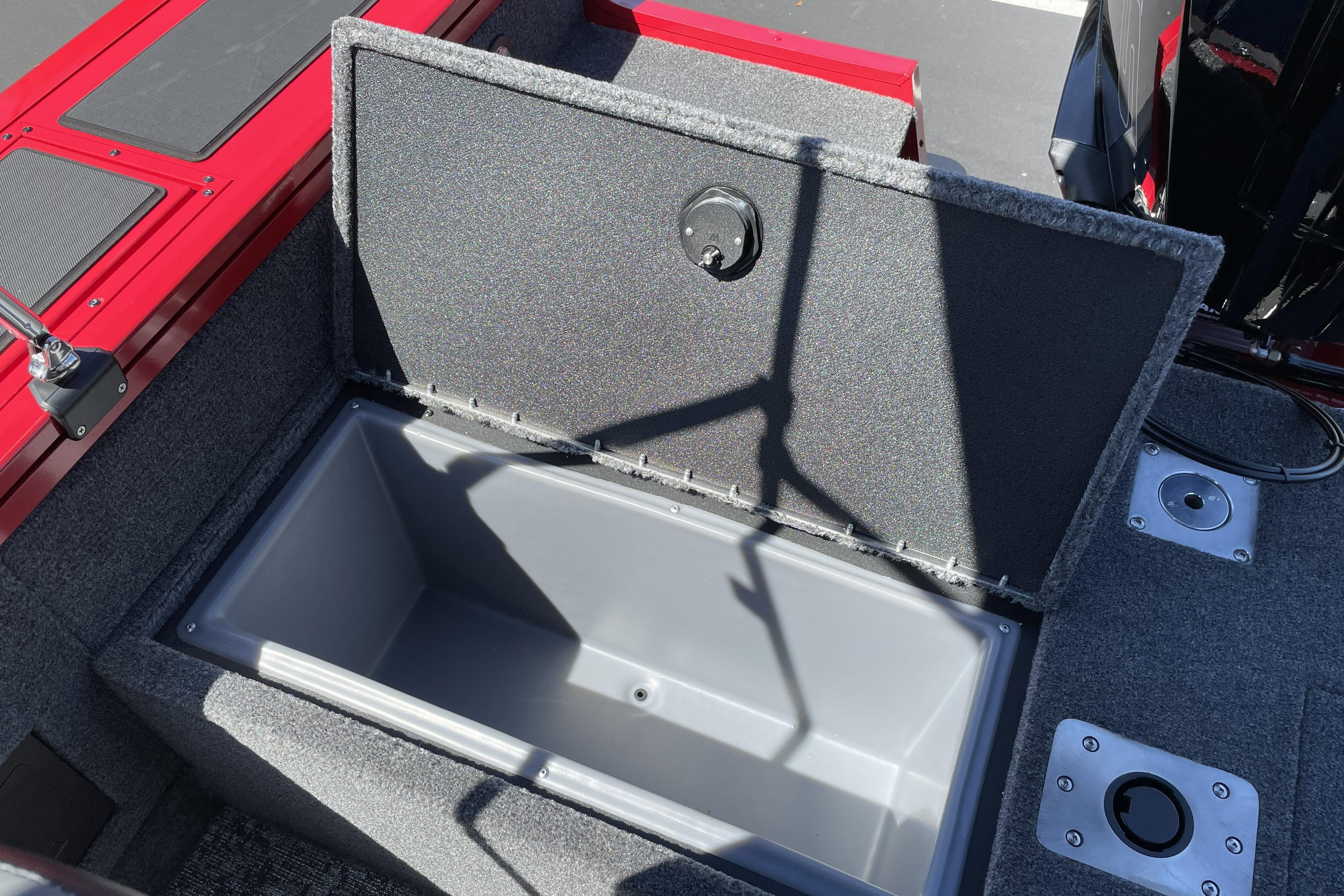 Open storage compartment in 2026 Tracker Targa V-18 WT boat, featuring red and gray interior.