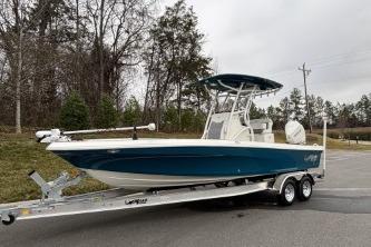 2026 Mako 24 APEX boat on trailer, parked outdoors, overcast sky.